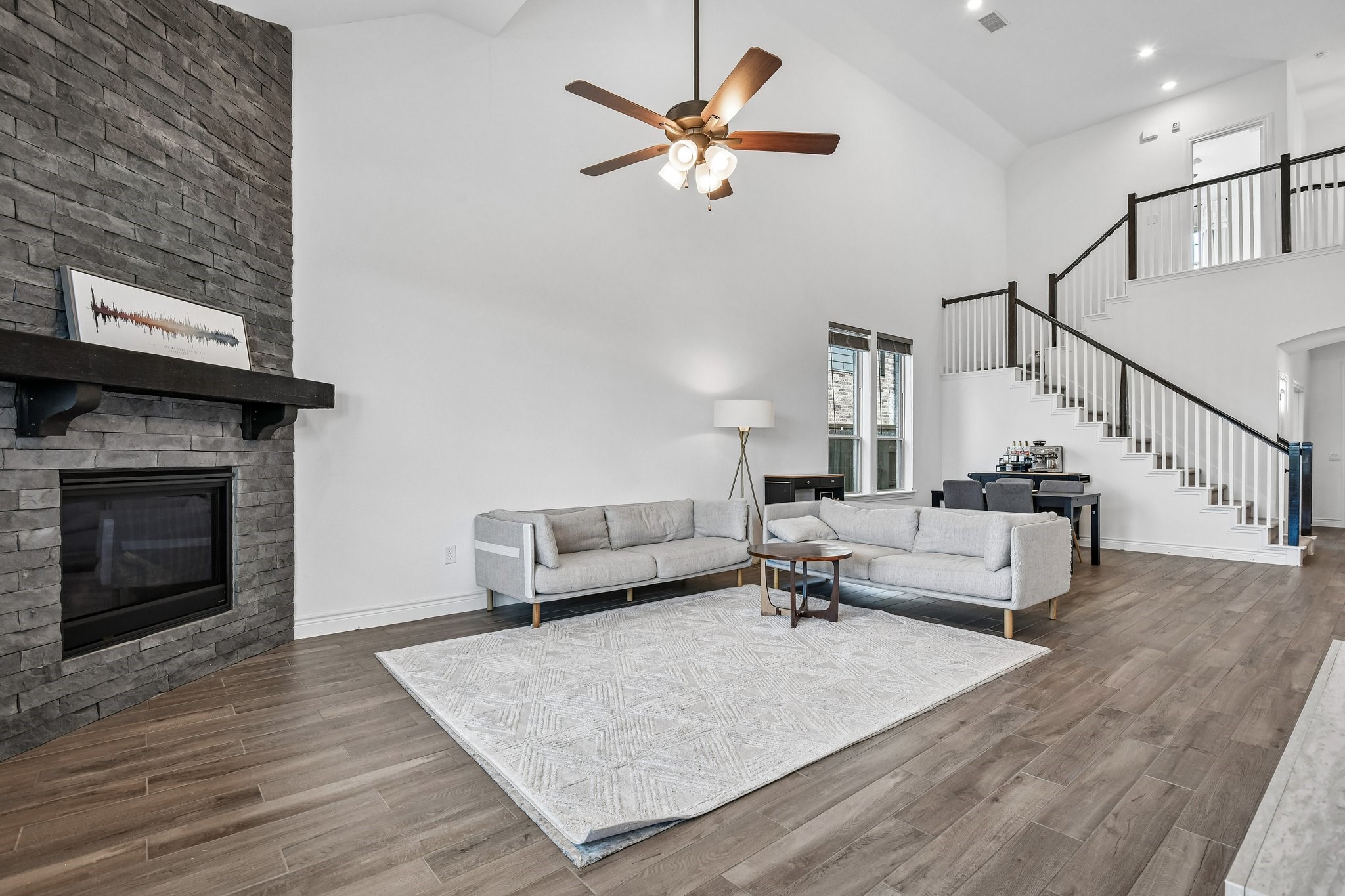 Second family room angle showing the open railing, tall ceilings, and connection to the kitchen