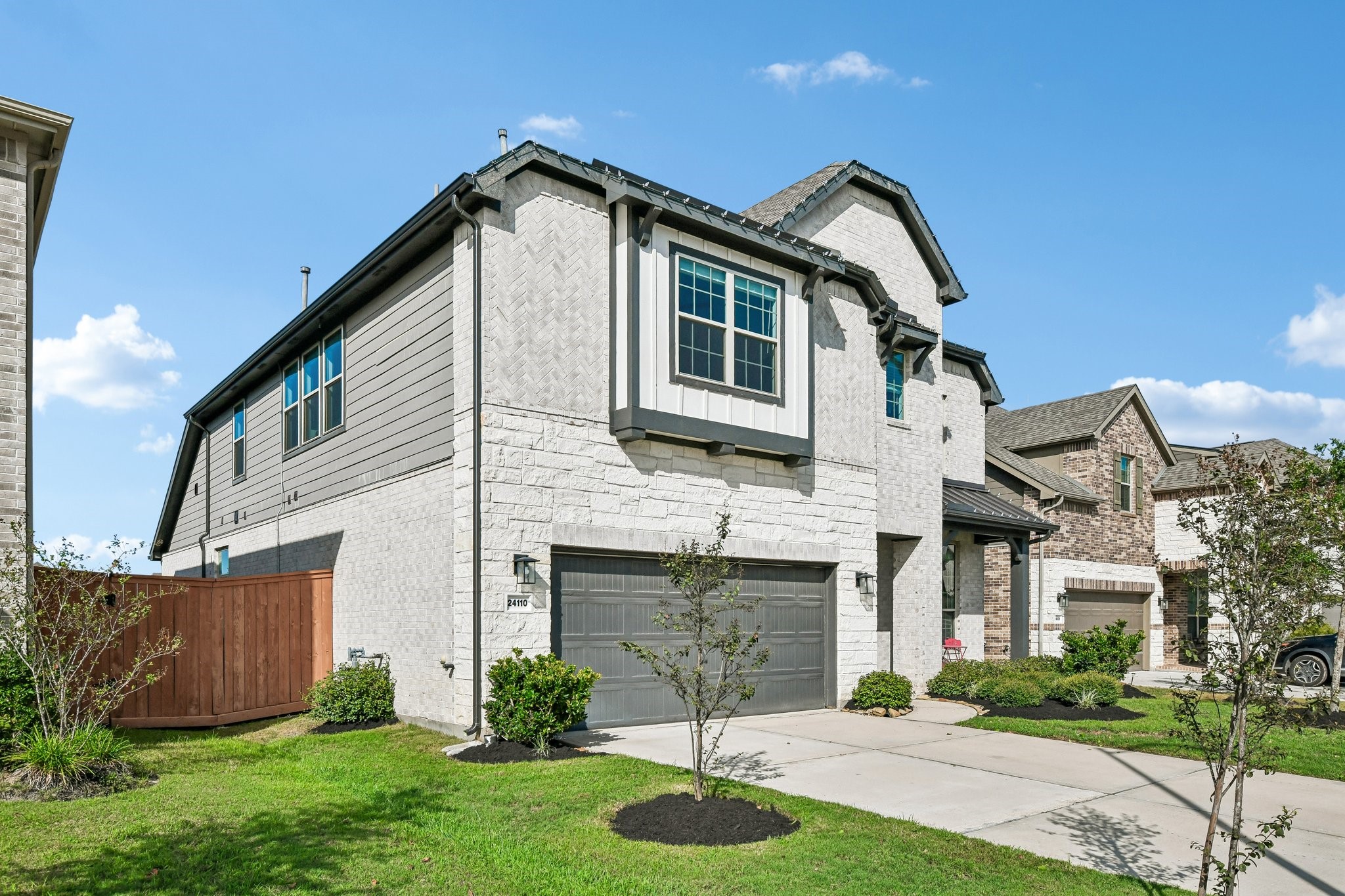 Side exterior view highlighting the depth of the home, roofline, and fenced yard access