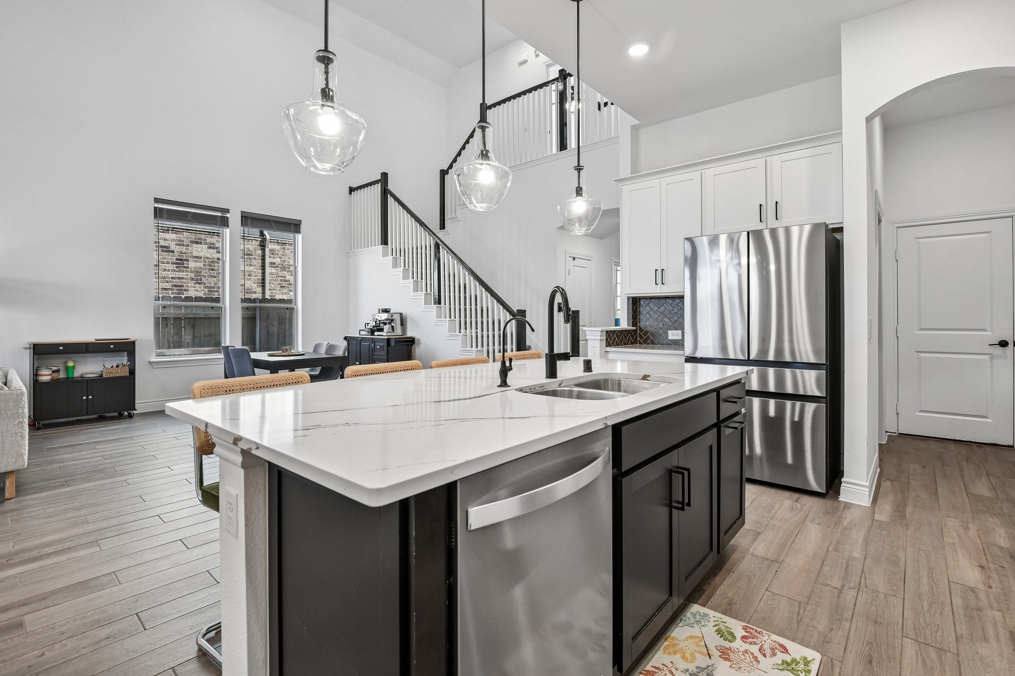 Opposite kitchen angle showing extensive cabinetry, prep space, and access to the pantry and wet bar