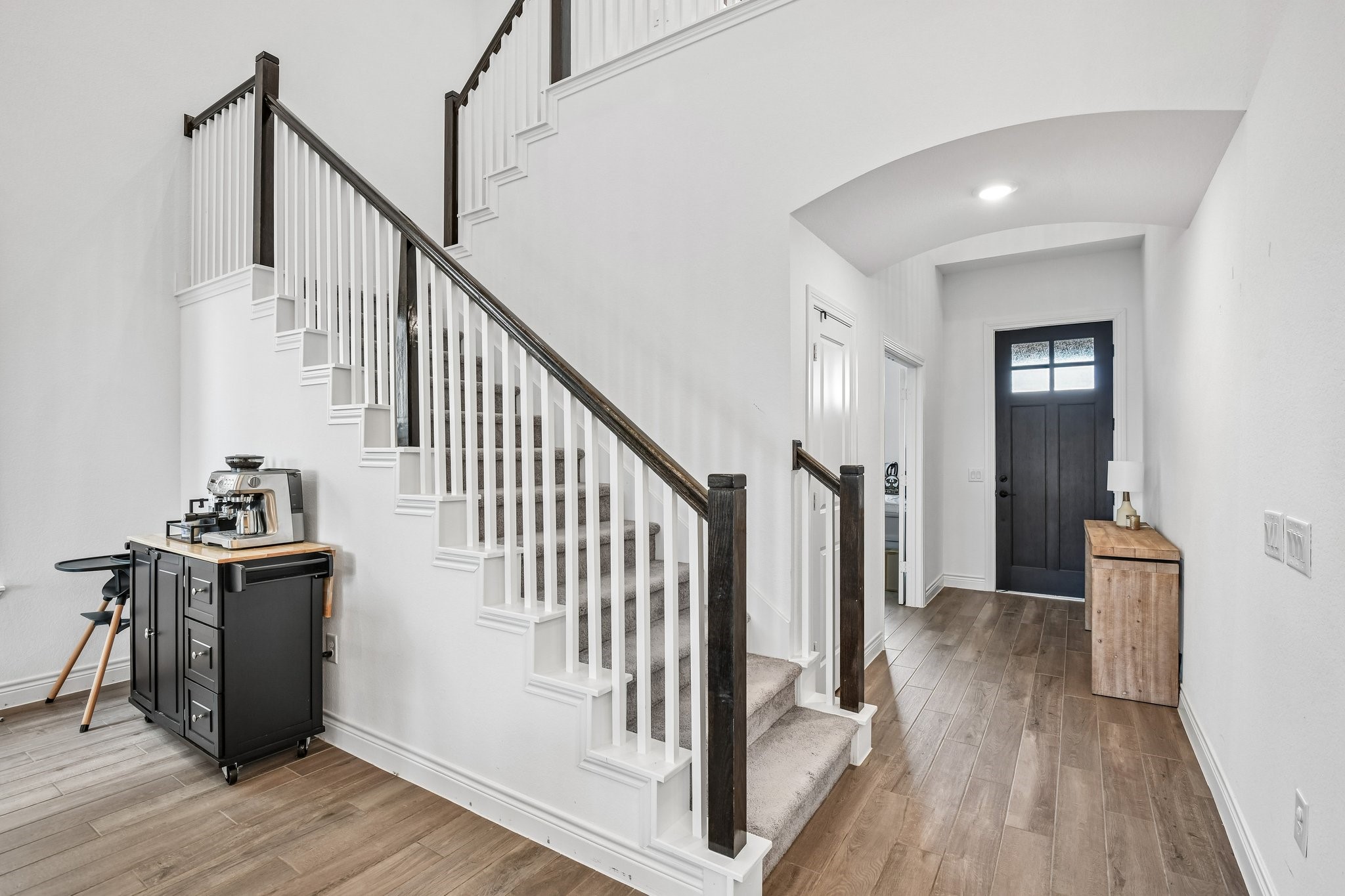 Open rail staircase overlooks the two-story family room and connects the upper and lower levels