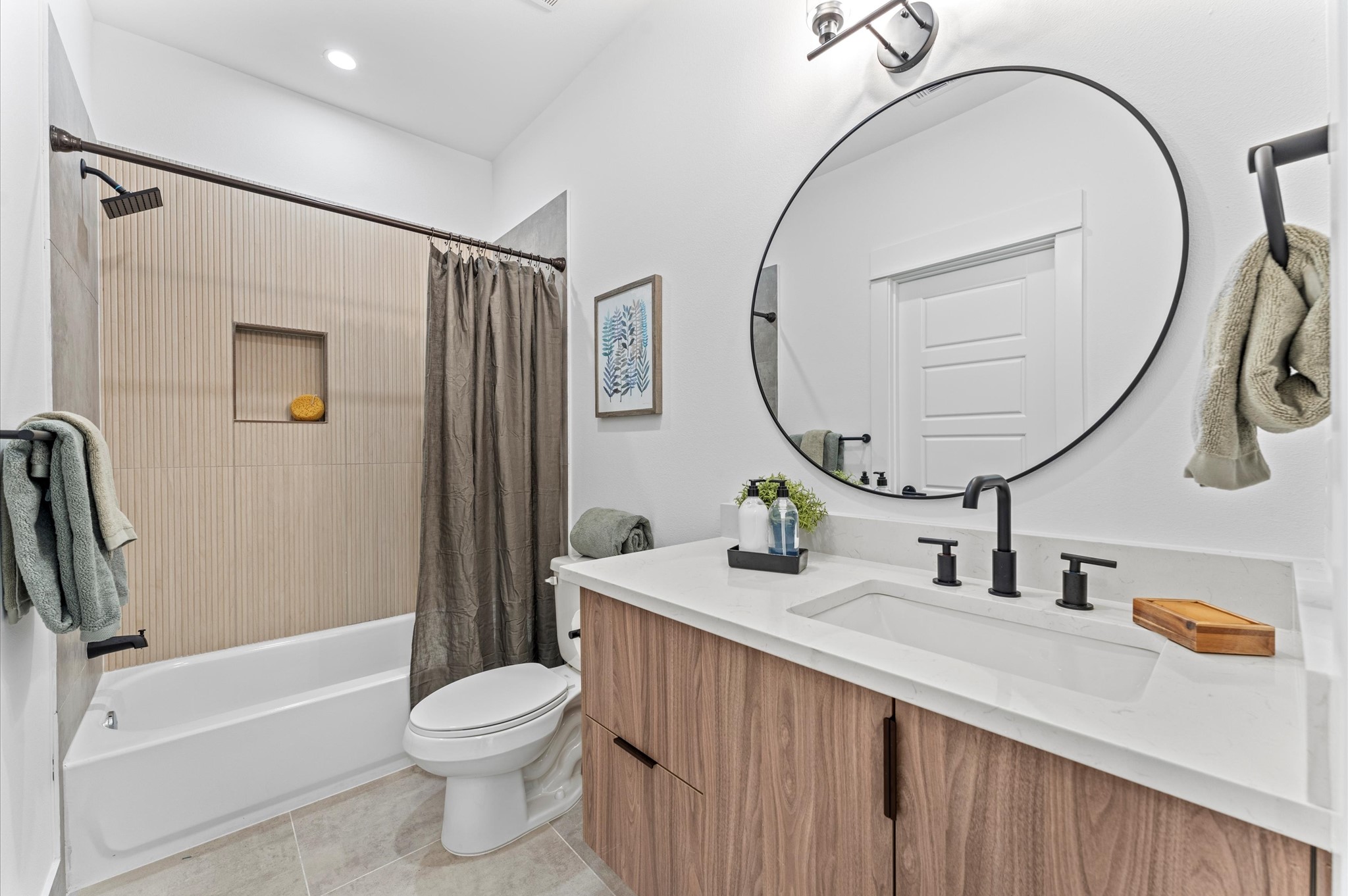 This thoughtfully designed Jack and Jill bathroom serves as a stylish and functional bridge between two spacious secondary bedrooms on the first floor. Featuring dual vanities, modern fixtures, and elegant tilework, the shared space offers privacy with separate entrances from each bedroom.