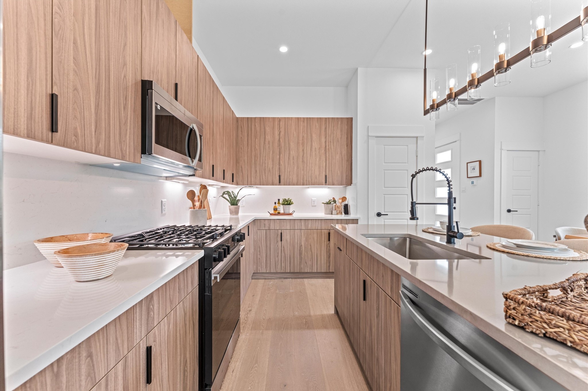 This modern kitchen showcases sleek contemporary cabinetry that blends minimalist design with high-end functionality. The layout maximizes storage with upper and lower cabinets and neutral tones complement quartz countertops and stainless steel appliances, completing the kitchens polished, sophisticated vibe. Ideal for those who appreciate modern elegance and smart design.