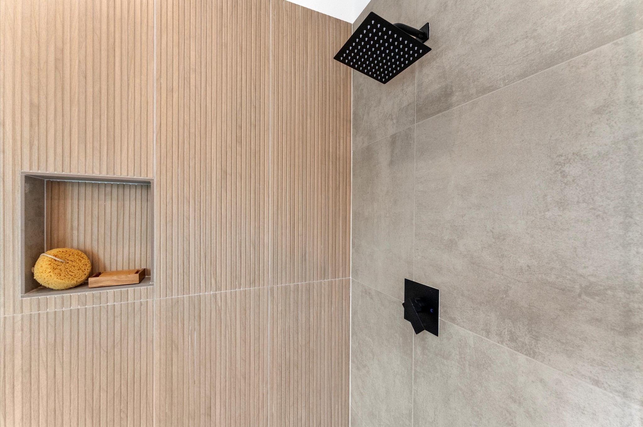 This luxurious primary bathroom blends modern elegance with spa-like comfort, featuring neutral tones, statement lighting, and refined tilework complete the space, creating a serene retreat thats both functional and visually stunning.