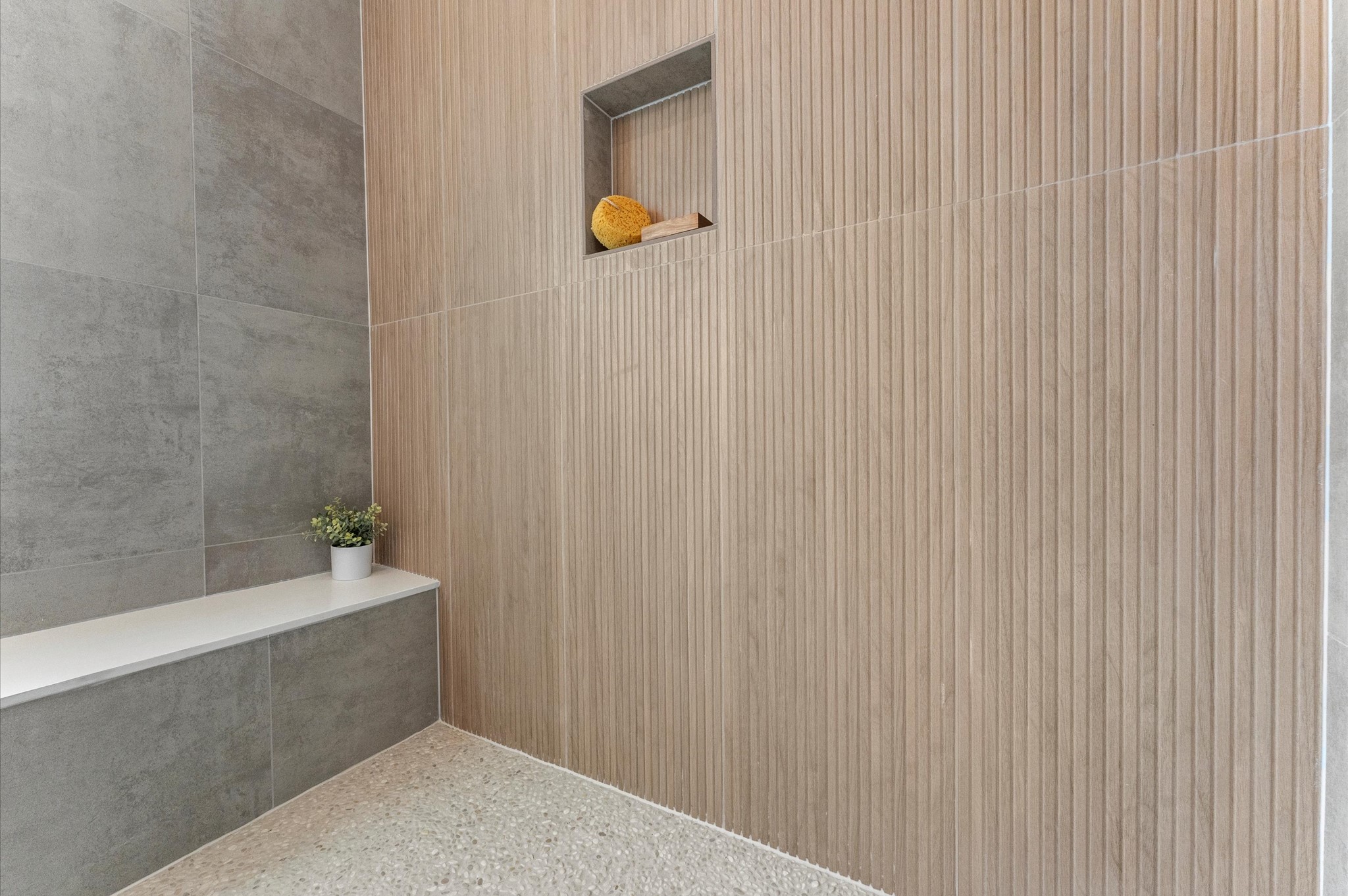 This luxurious primary bathroom blends modern elegance with spa-like comfort, featuring neutral tones, statement lighting, and refined tilework complete the space, creating a serene retreat thats both functional and visually stunning.