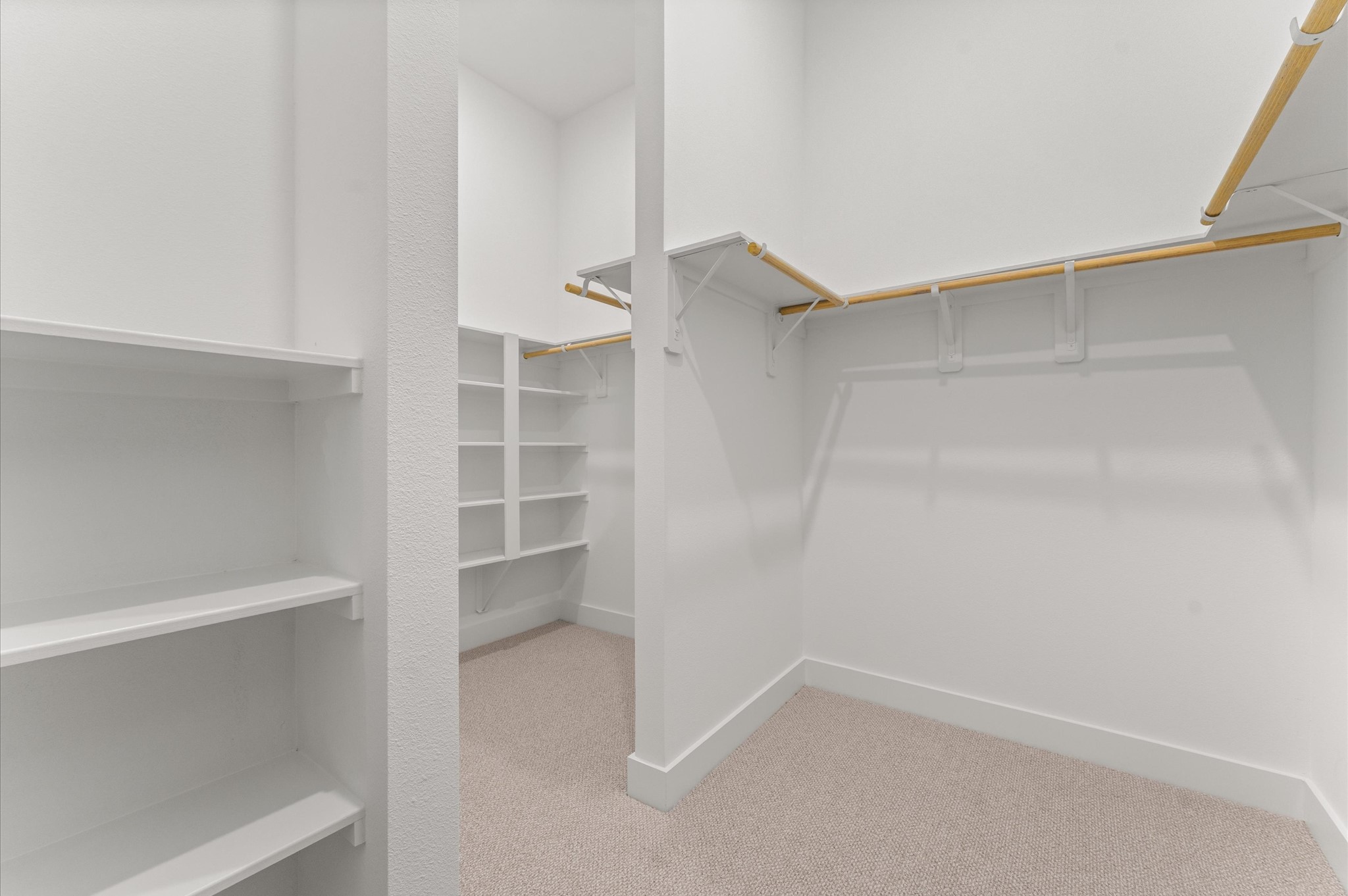 This expansive walk-in closet is a standout feature of the primary bedroom, offering generous space for wardrobe organization and personal storage. Thoughtfully designed shelving and hanging rods, the closet provides a boutique-like experience with room for everything from seasonal clothing to accessories.