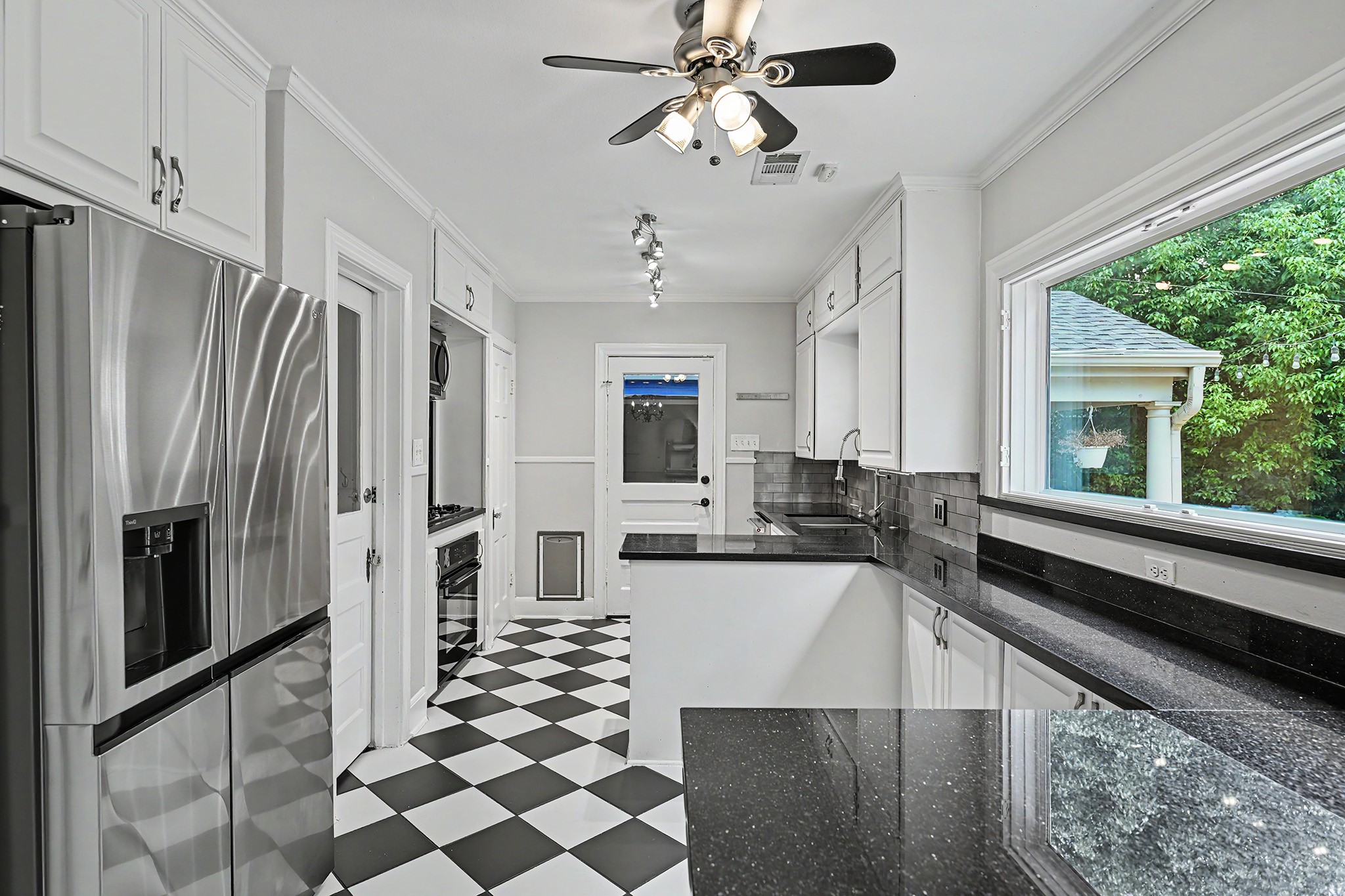 The kitchen features a large picture window overlooking the backyard, along with abundant cabinet storage and counter space.