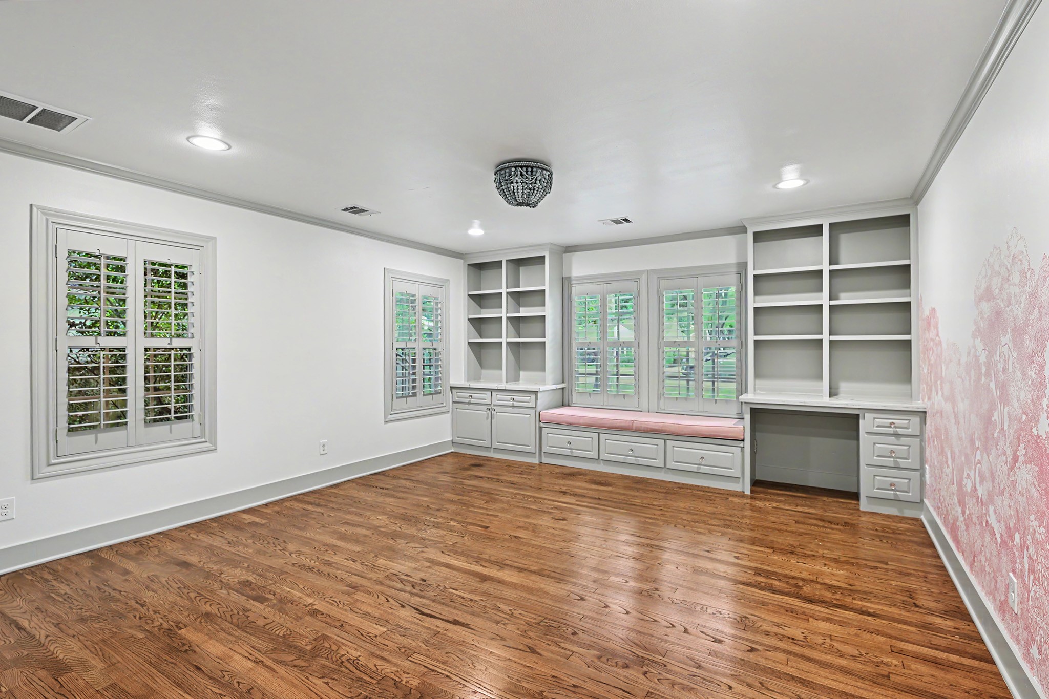 Large and bright 1st floor secondary bedroom is ideal for family or guests, with hardwood floors, a built-in desk and storage, plus a charming window seat.
