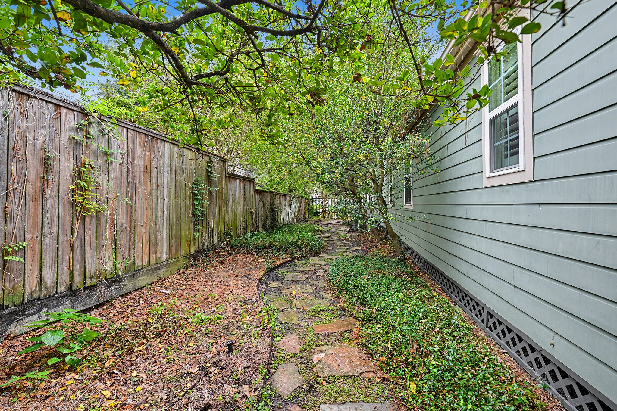 The side yard includes a landscaped paver pathway and additional outdoor space to enjoy.