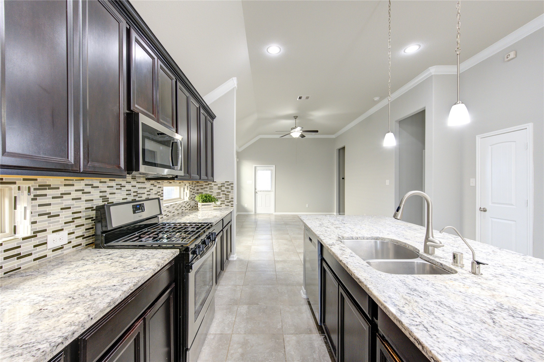 This photo shows a laundry area with washer and dryer hookups, a wall-mounted shelf for storage, and utility connections. The space is clean and ready for appliances.