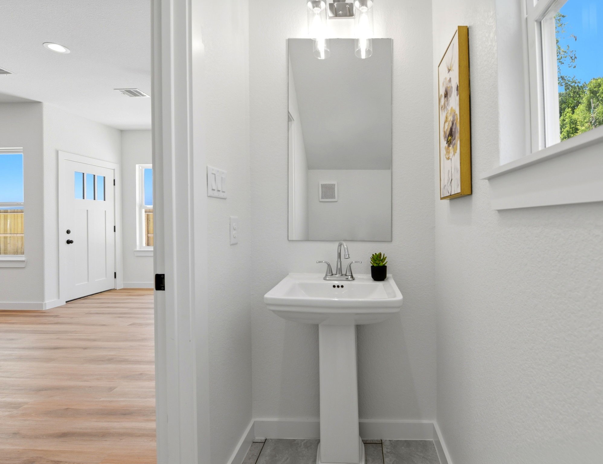 Half bathroom downstairs. The space is bright with natural light from window.