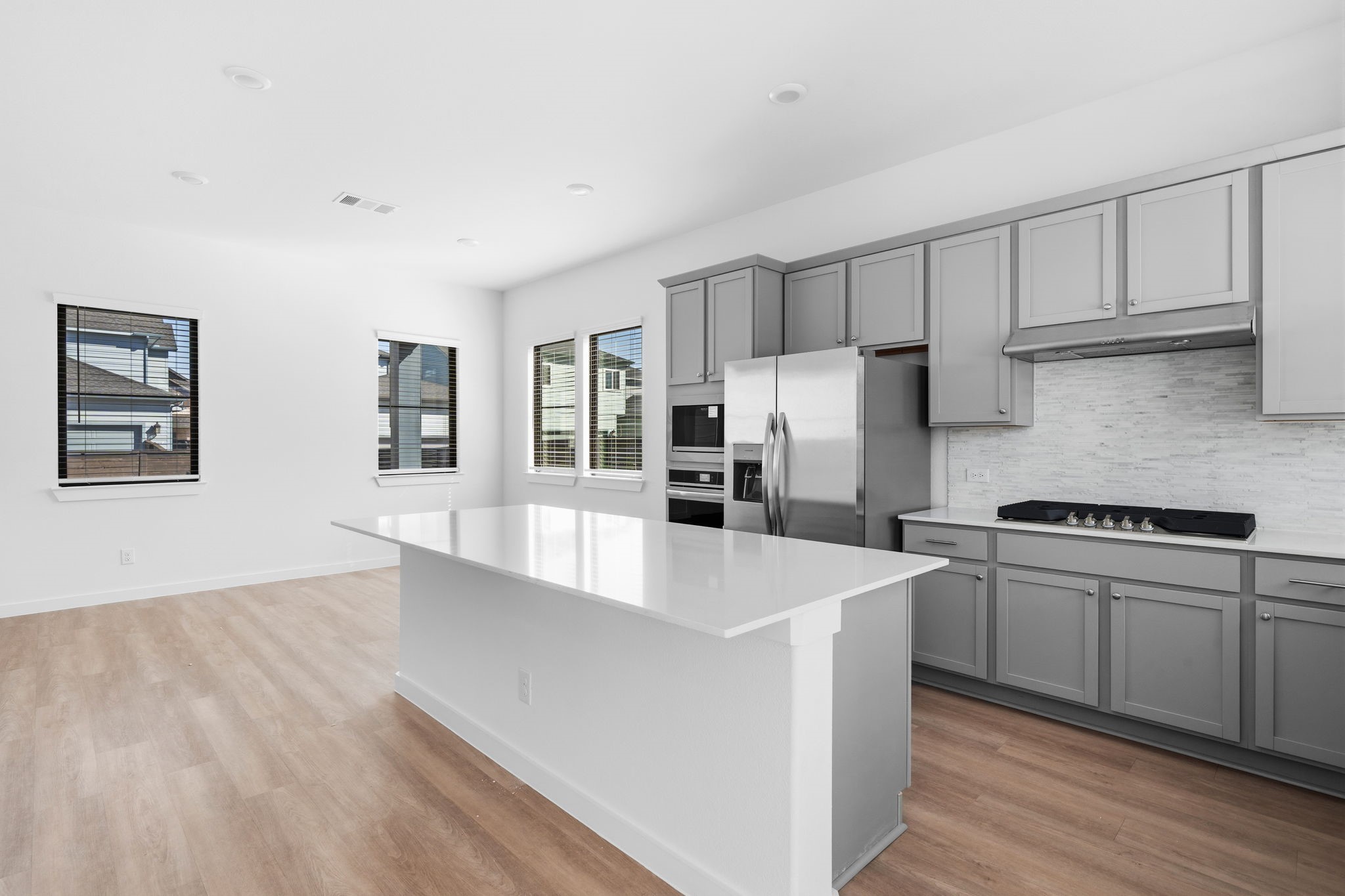 The heart of the home is always the kitchen, and this one is designed to make everyday cooking and entertaining feel effortless. Featuring elegant white quartz countertops, sleek gray cabinetry, a full range, stainless steel appliances, and a spacious central island, it is a beautiful space to gather, create, and make memories.