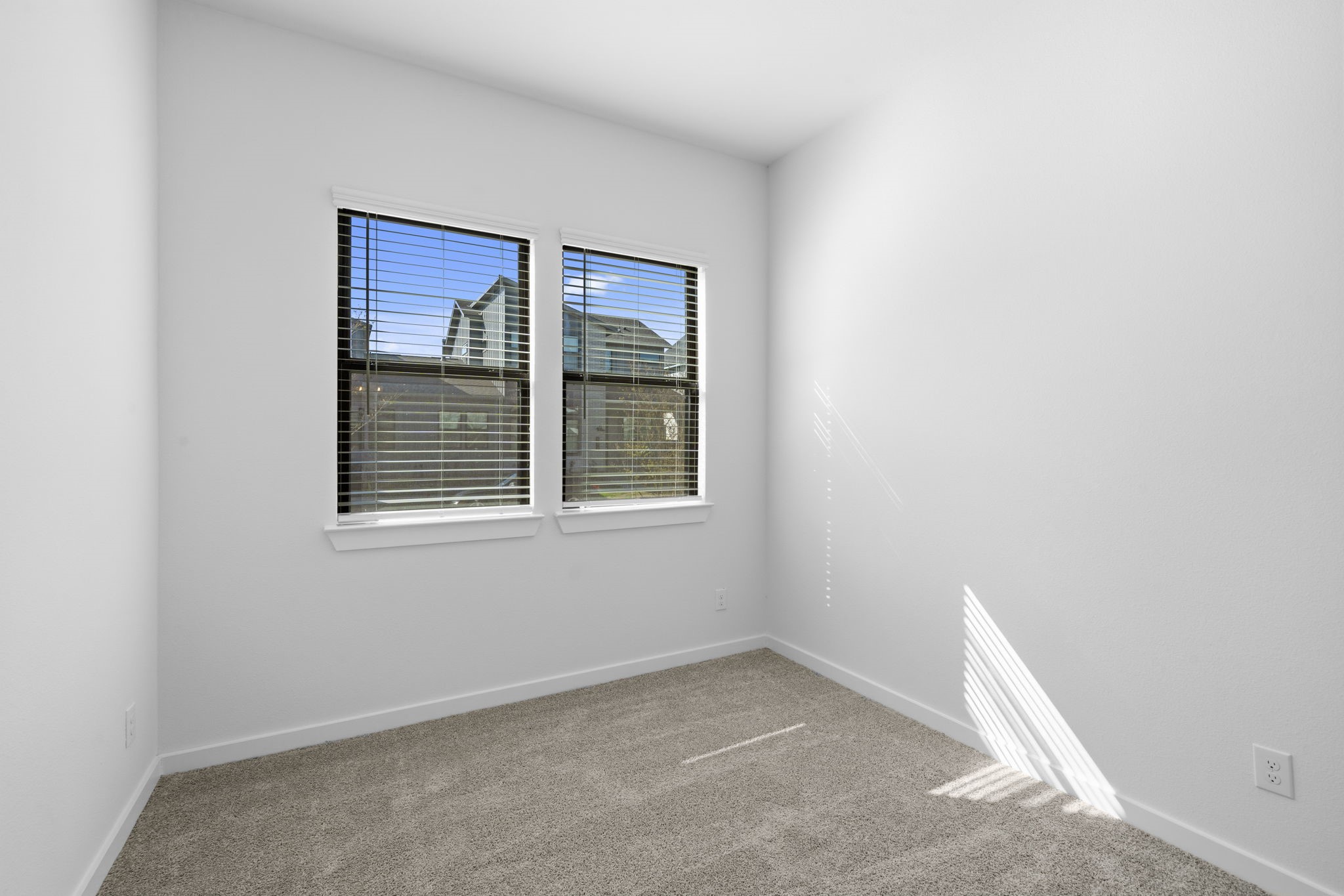 The downstairs bedroom offers a bright and comfortable retreat with two large windows that fill the space with beautiful natural light. With its cozy carpet and neutral finishes, it is ready to become a welcoming guest room or a space that feels entirely your own.