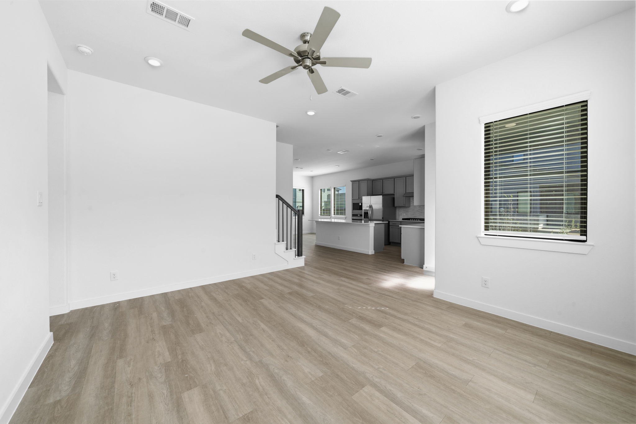 Just steps from the main entry, the living room welcomes you with an open, airy layout and plenty of space to settle in. With warm wood look flooring, recessed lighting, and a bright blank canvas, you can easily create a space that feels uniquely yours for cozy nights and memorable gatherings.