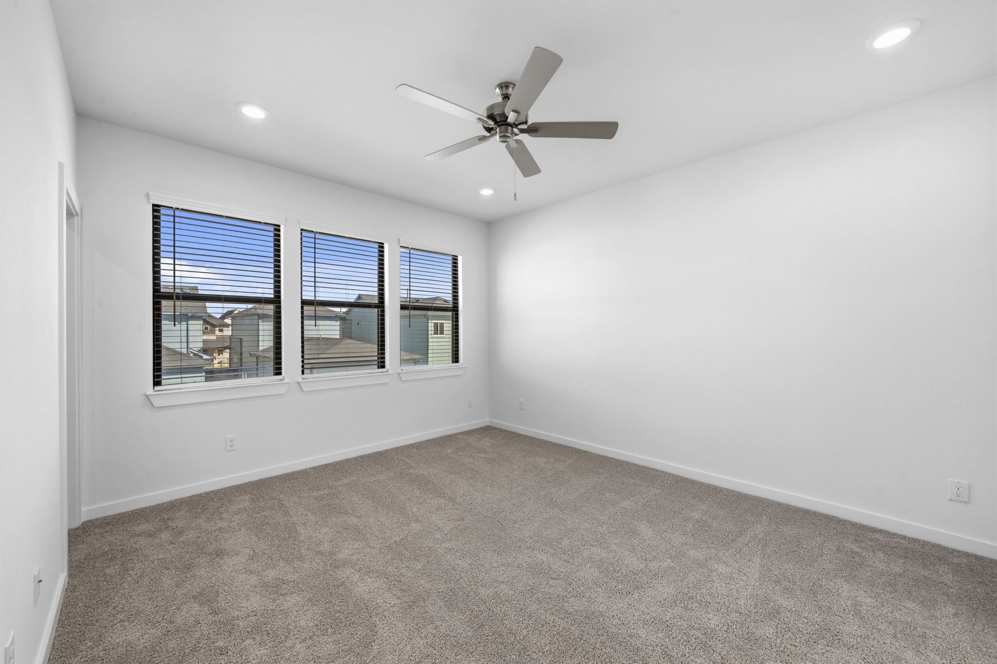 Enjoy a peaceful retreat in the primary suite, where three large windows overlook the back of the home, bringing in beautiful natural light while offering an added sense of privacy.