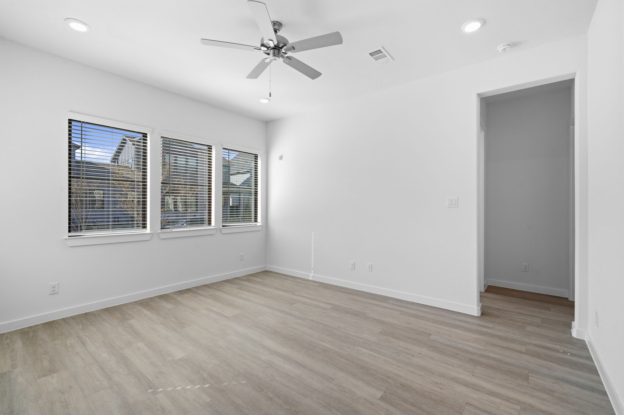The living room welcomes you with beautiful natural light, recessed lighting, and plenty of space to create a comfortable setting for everyday living. Just down the hallway, the conveniently located downstairs guest bedroom and full bathroom offer a private and welcoming space for overnight guests or family.