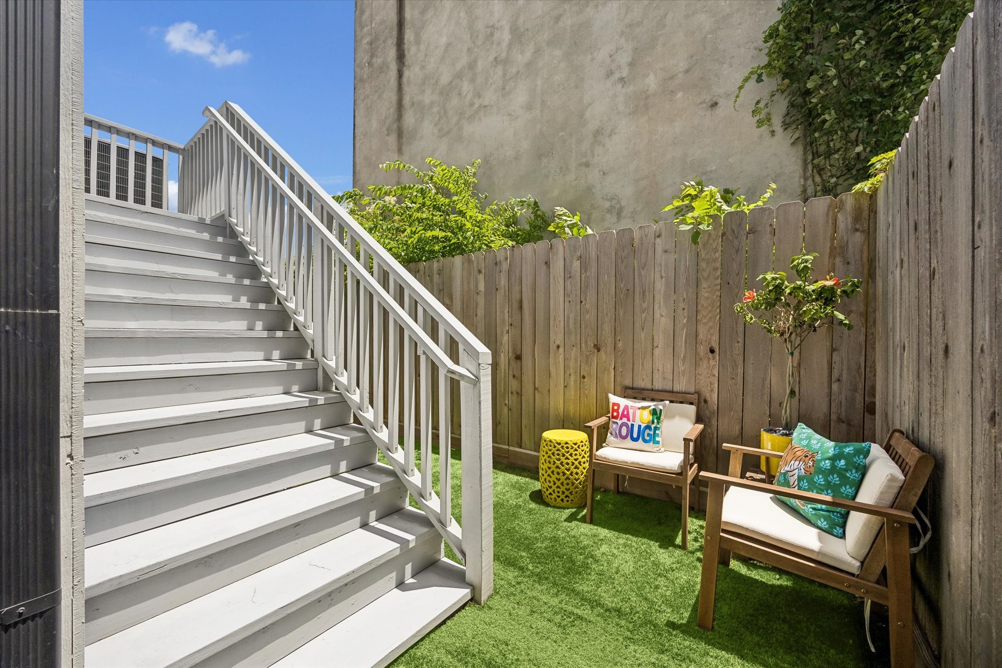 Enjoy care-free outdoor living with this small fenced yard with artificial turf, perfect for a cozy seating area, with easy access to the back deck and first-floor guest suite.