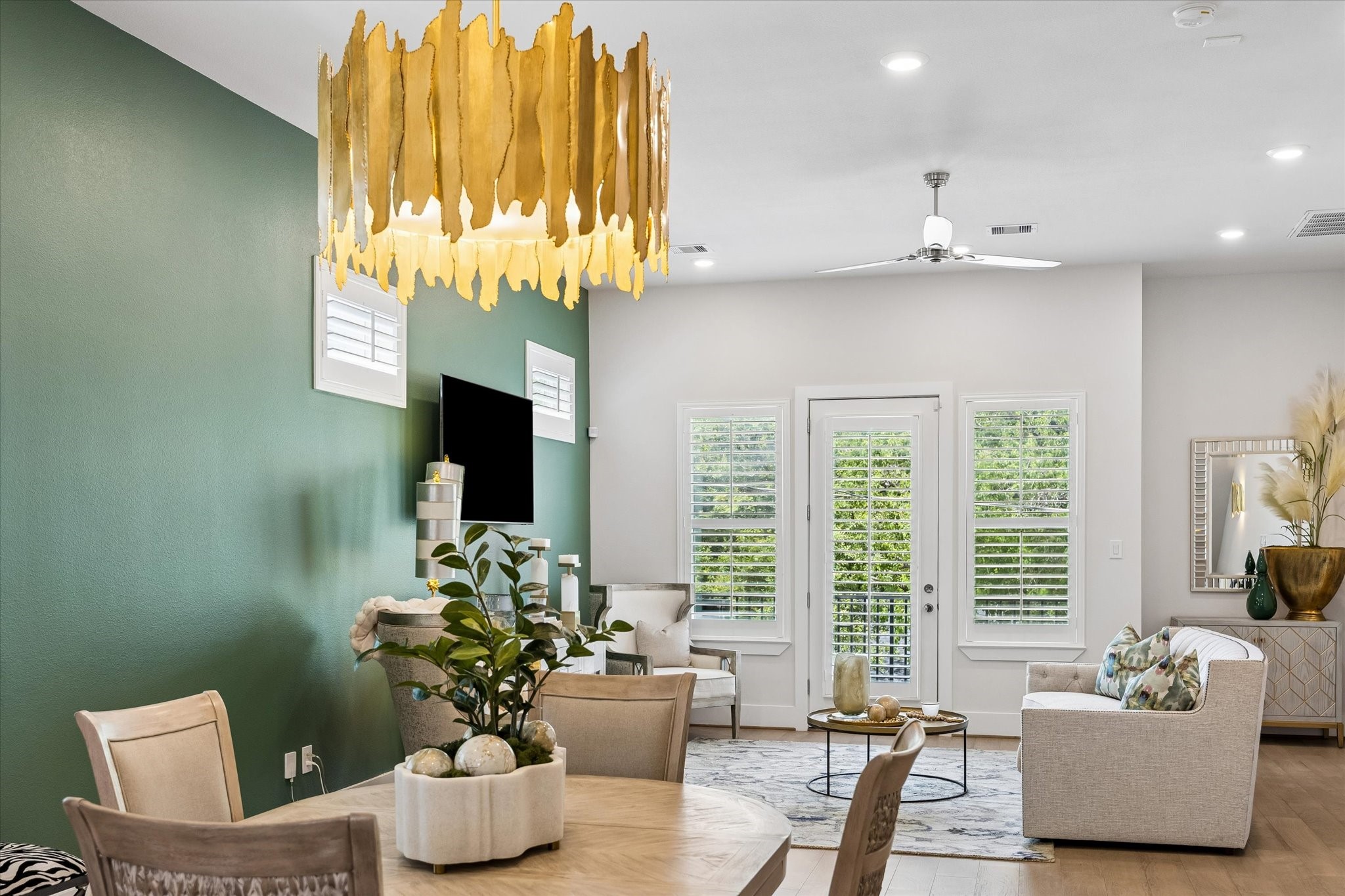 Designer details shine from the dramatic chandelier and rich accent wall to the wood shutters and open flow that makes entertaining feel easy.