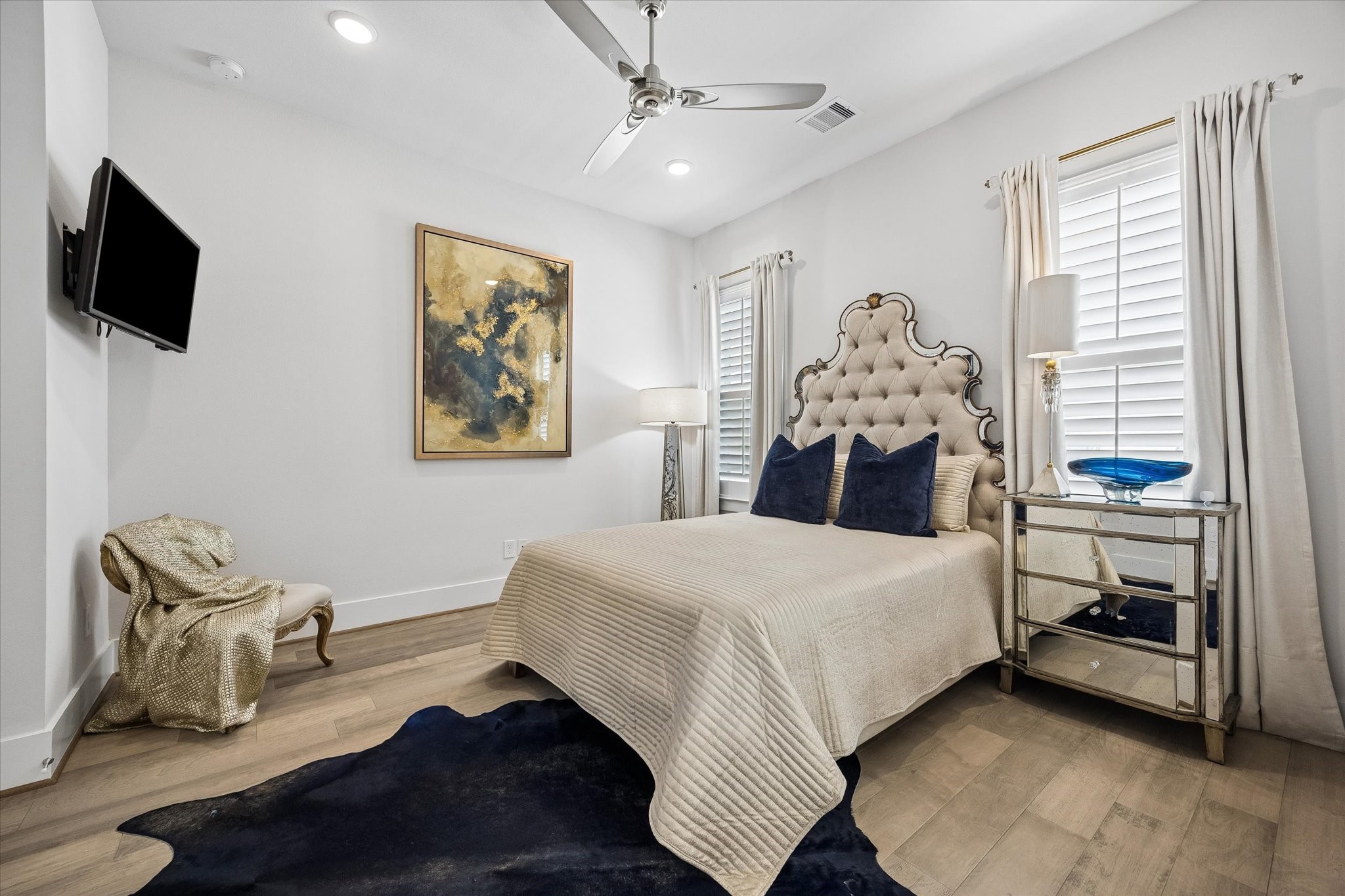 This third-floor guest suite offers a comfortable retreat with engineered wood flooring, wood shuttered windows, recessed lighting, a large closet, ensuite bathroom, and plenty of room to settle in and feel right at home.