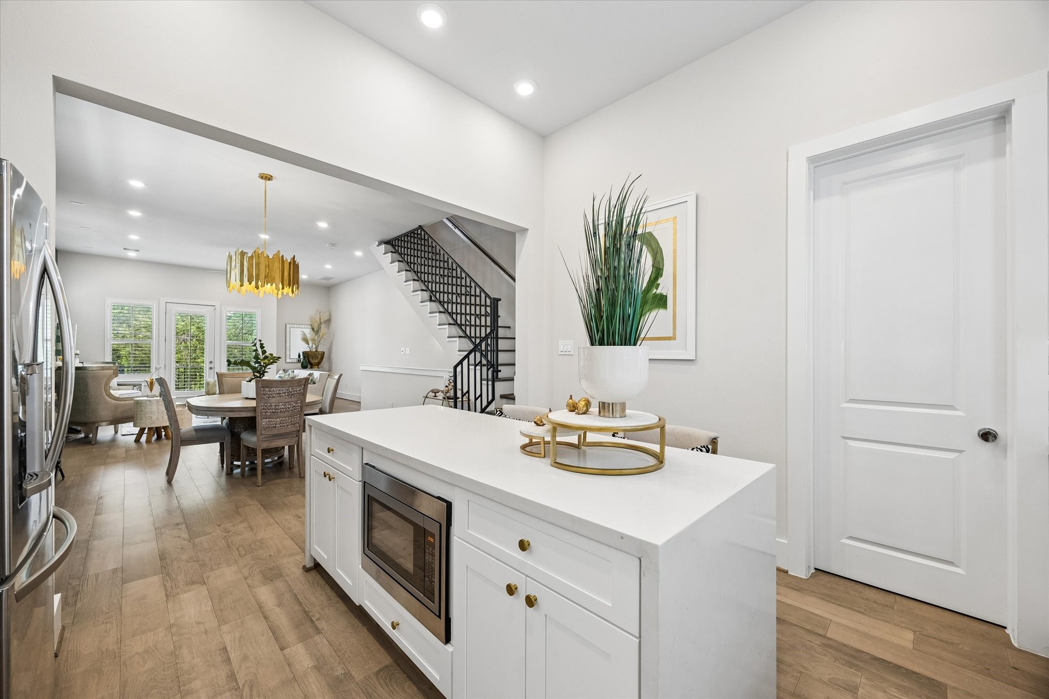 The waterfall island adds both style and function with quartz counters, an in-island microwave, extra storage, and bar seating that keeps the kitchen connected to the dining and living areas. Through the door, a very large walk-in pantry keeps everyday essentials neatly organized and tucked out of sight.