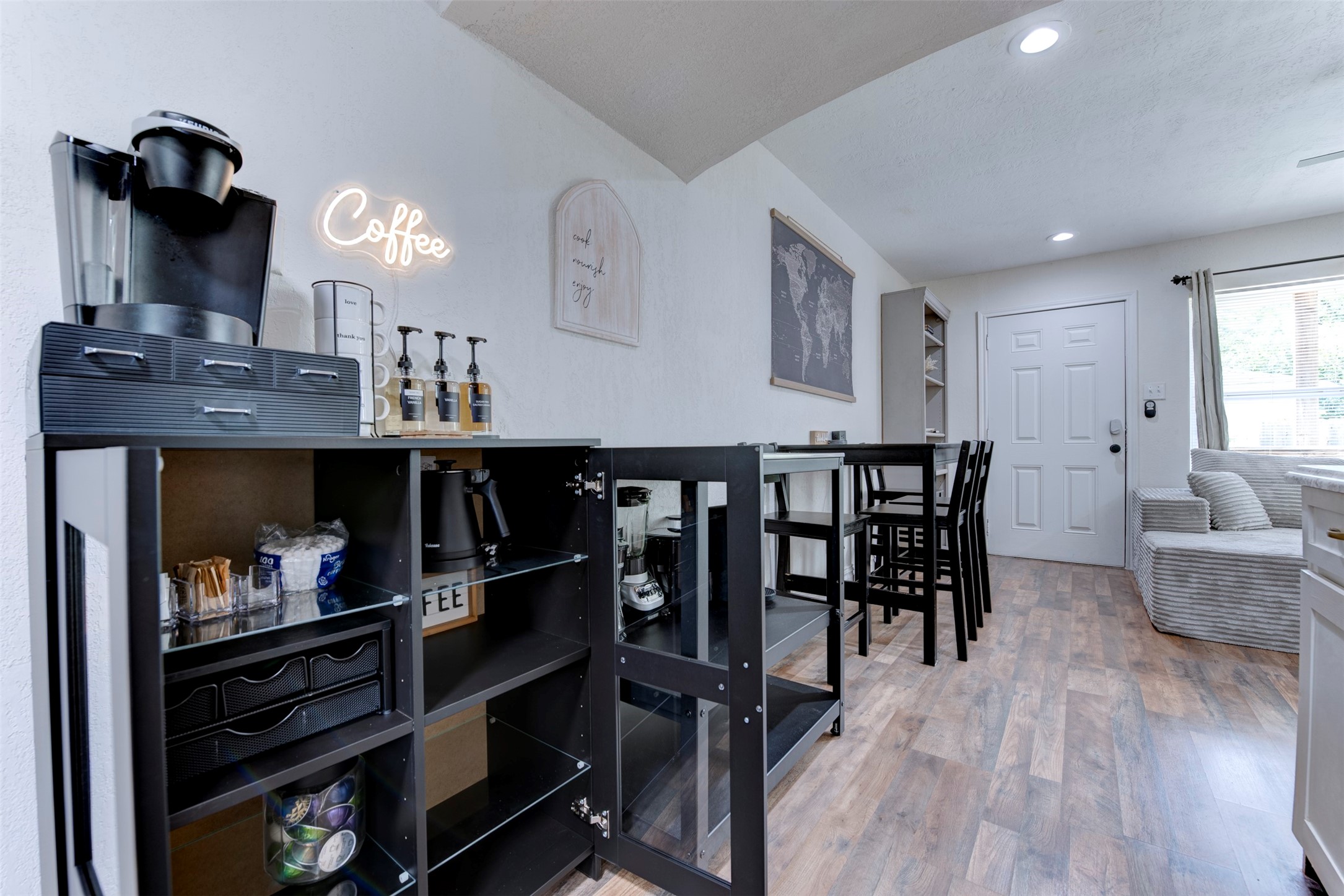 Dining area with bar-height seating, dedicated coffee station, recessed lighting, and smart lock entry