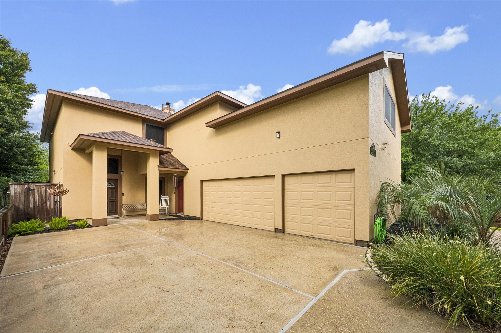 Two-story home with exterior stucco finish, covered front entry to the home and garage with an expansive driveway leading to a three-car garage. Mature landscaping and clean architectural lines provide strong curb appeal. Two-story home with exterior stucco finish, covered front entry to the home and garage with an expansive driveway leading to a three-car garage. Mature landscaping and clean architectural lines provide strong curb appeal.