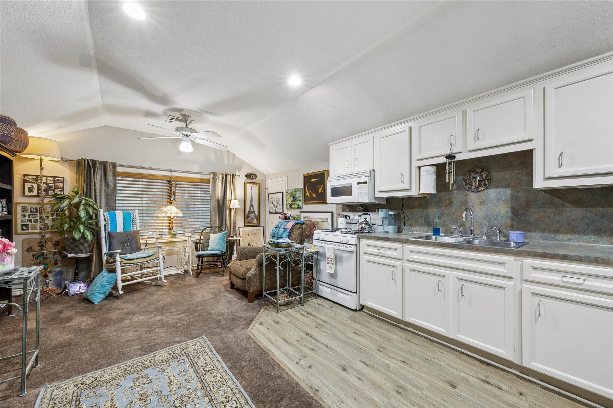 Secondary view of the garage apartment showcasing full kitchen with ample cabinetry and open living area. Vaulted ceiling and flexible layout support or guest accommodations.