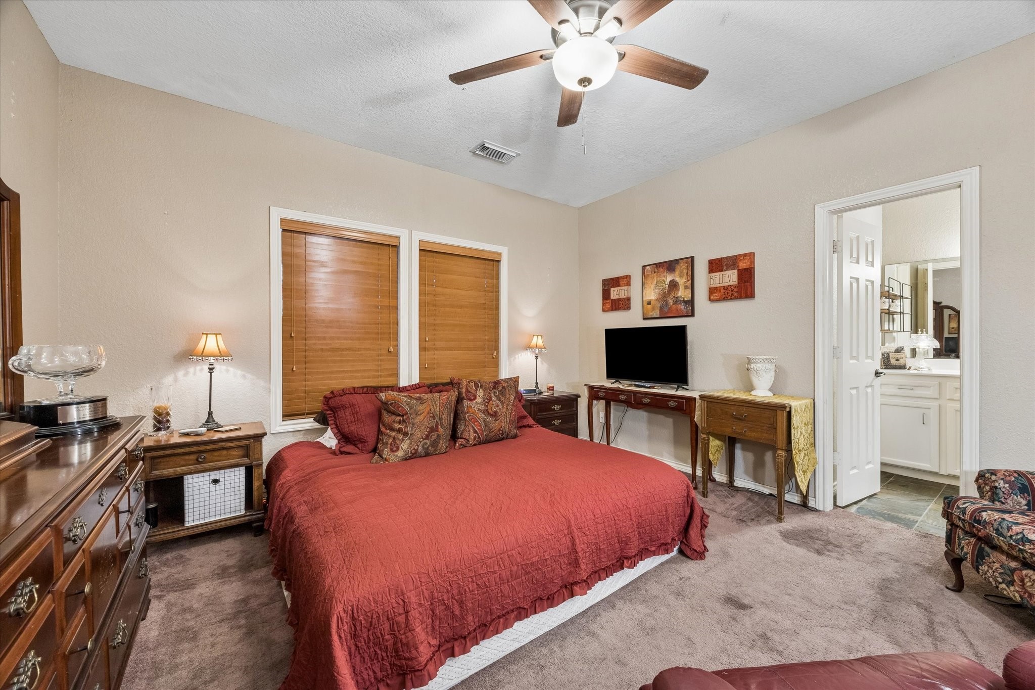 Downstairs bedroom/unit with ceiling fan and natural light, featuring a private en-suite bathroom with walk-in shower. Ideal for guests, multigenerational living, or private rental use.