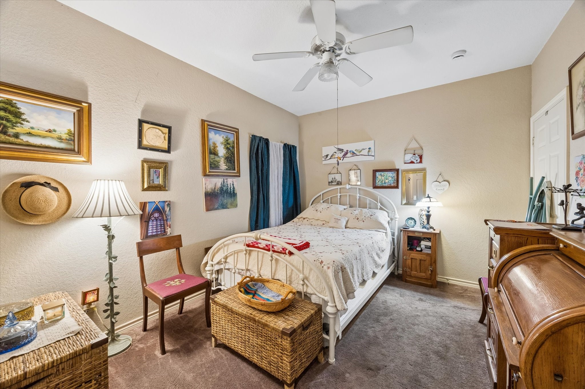 Private bedroom within the garage apartment featuring ceiling fan, natural light, and comfortable layout. Ideal for guests or rental space with separation from the main residence.