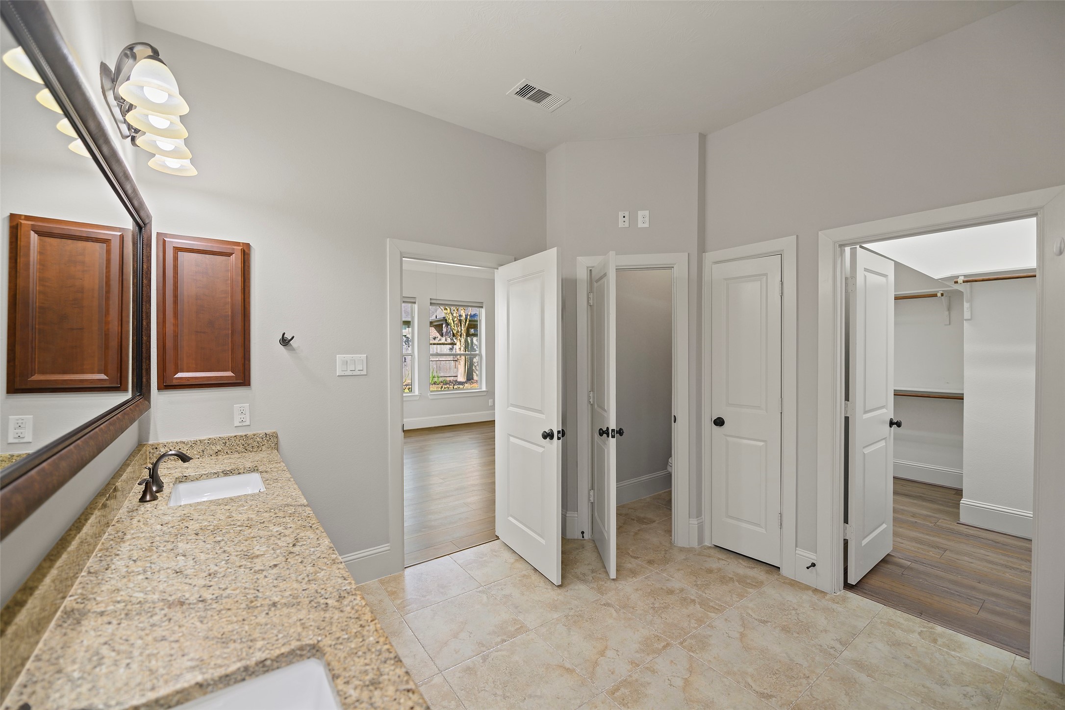 Primary bathroom with dual sinks, granite countertops and separate powder room.