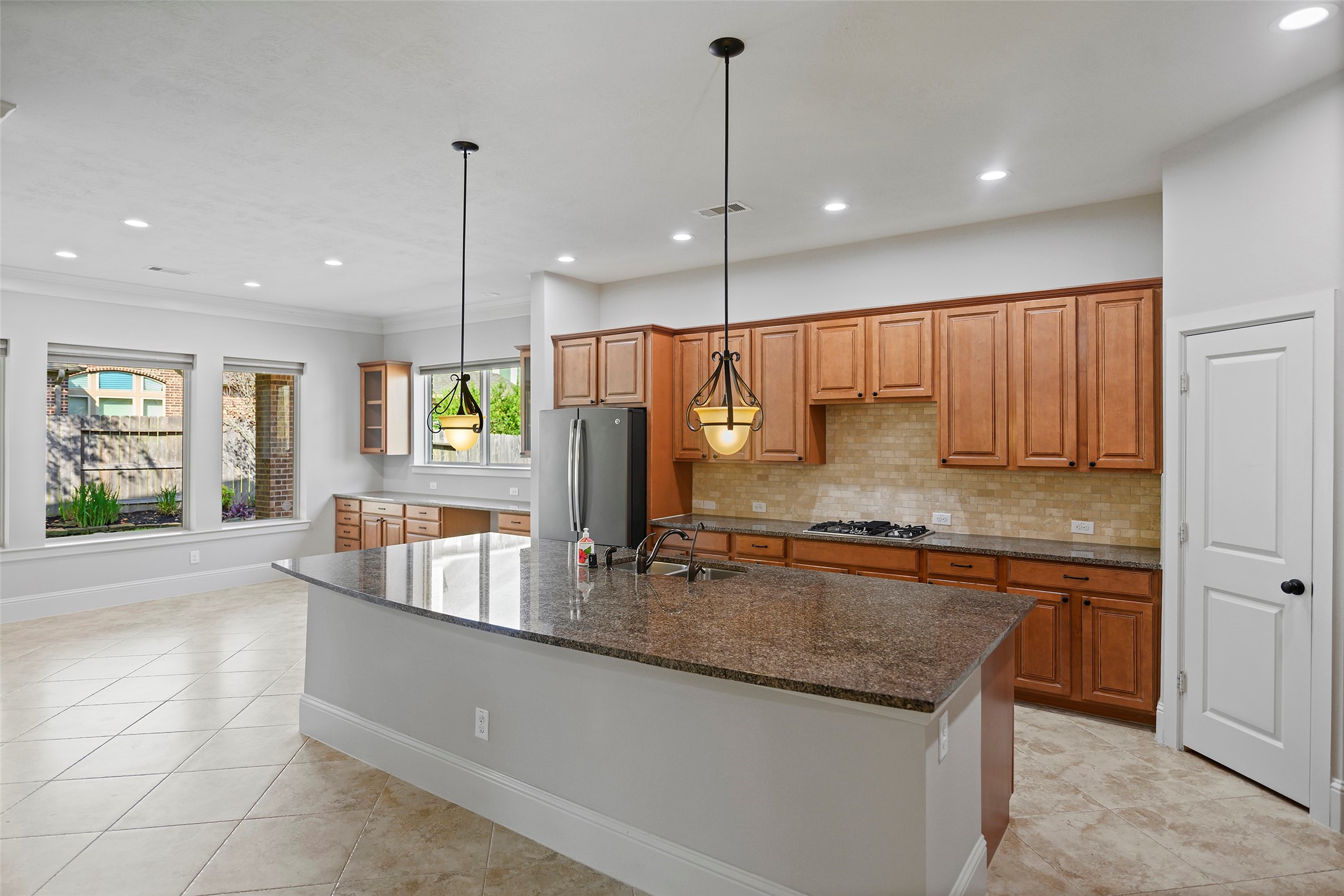 Kitchen with gas cooktop, stainless steel appliances, granite countertops, and huge breakfast bar is a chef's delight.