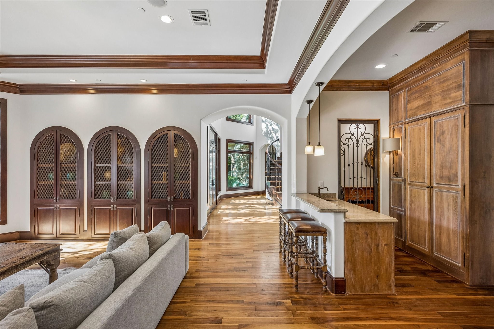 The family room opens to a convenient wet bar with stone countertops, custom wood cabinetry, and wine storage, creating an inviting space for everyday living and entertaining.