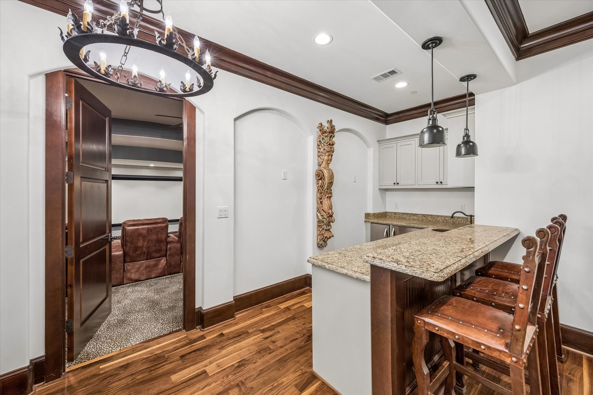 Conveniently located between the media room and upstairs game room, this bar area features granite countertops, bar seating, a sink, and beverage storage for easy entertaining.