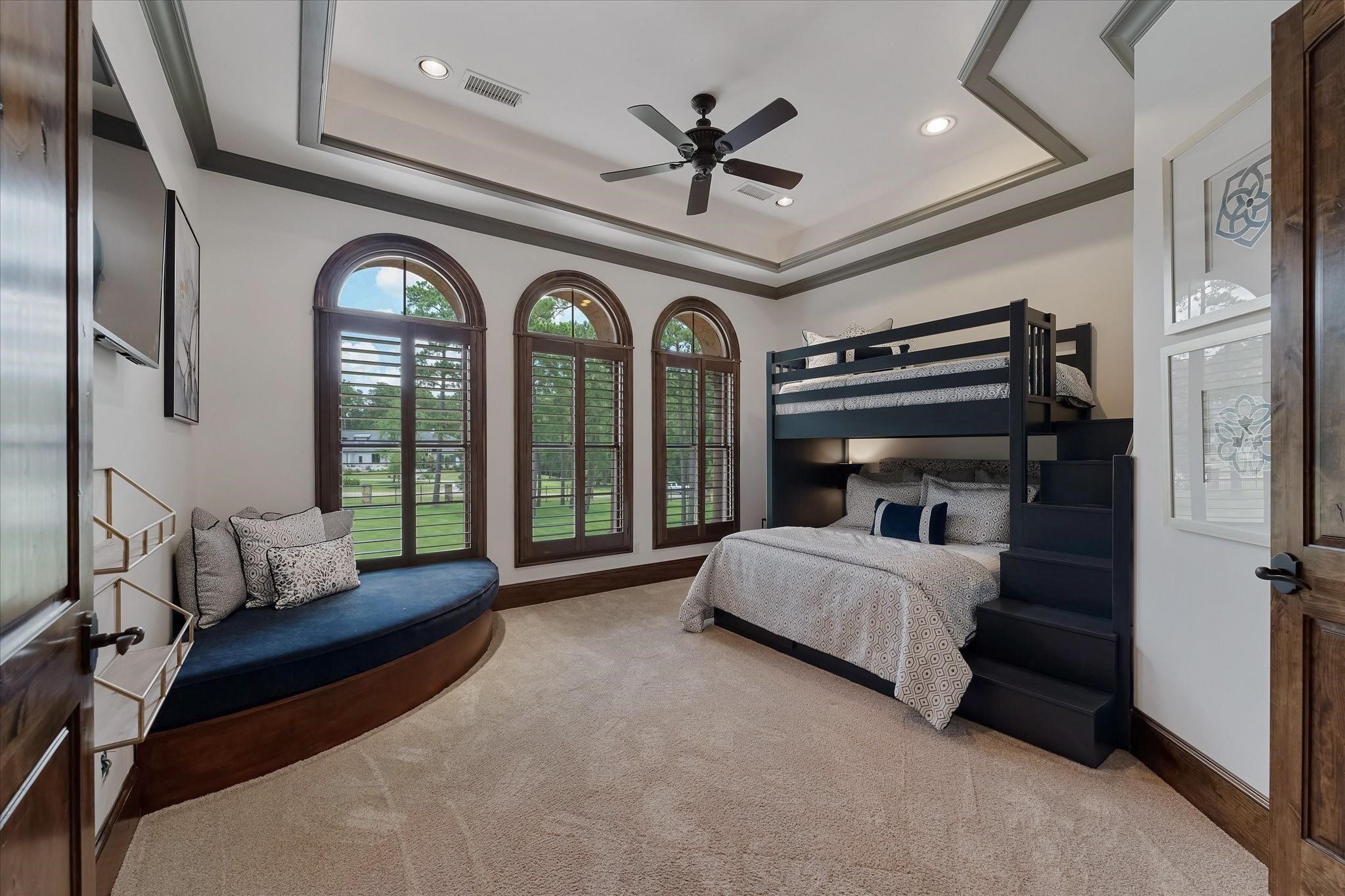 Guest bedroom #2 on the 2nd floor. Dual Mahogany Door Entry, Custom Built-in Bunk Beds with custom built-in corner bench. Three large arched windows with custom wood shutters provide northern exposures and a view of the front yard. Custom crown molding, Custom Tray Ceiling With Cove Lighting.