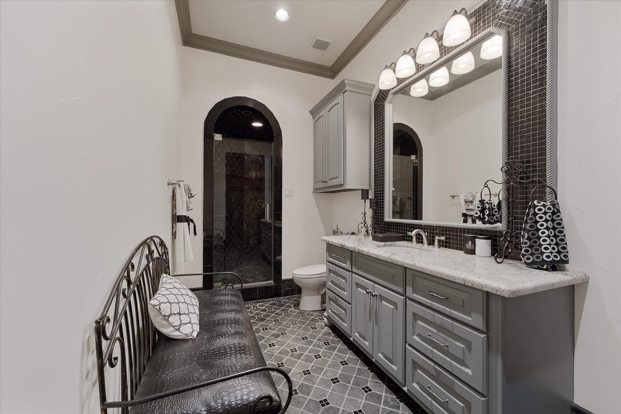 Guest bedroom ensuite #3 on the second floor.
Custom tile flooring with an intricate pattern, a shower with a built-in bench. Alpine granite countertop vanity with Custom framed mirror. Walk-in Closet With built-ins and a window providing northern exposures and views of the front yard, door Jamb Light Switch.