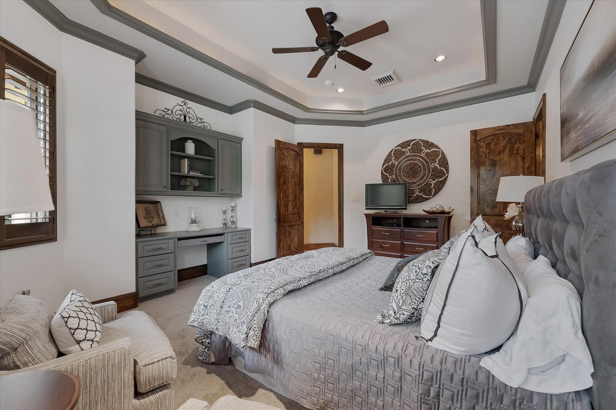 Guest Bedroom #3 on the second floor. Includes built-in desk with custom cabinetry that offers lower closed storage and open shelving. Windows offer views of the backyard and southern exposures.