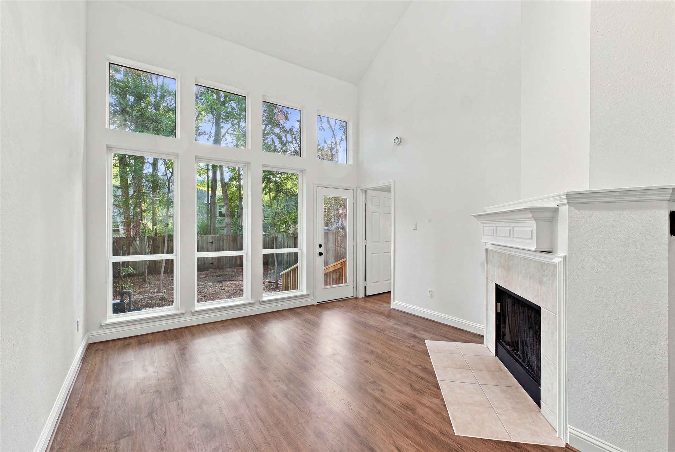 The living room features vaulted ceilings, a wall of windows, a fireplace and direct backyard access, creating a comfortable space to relax or entertain.