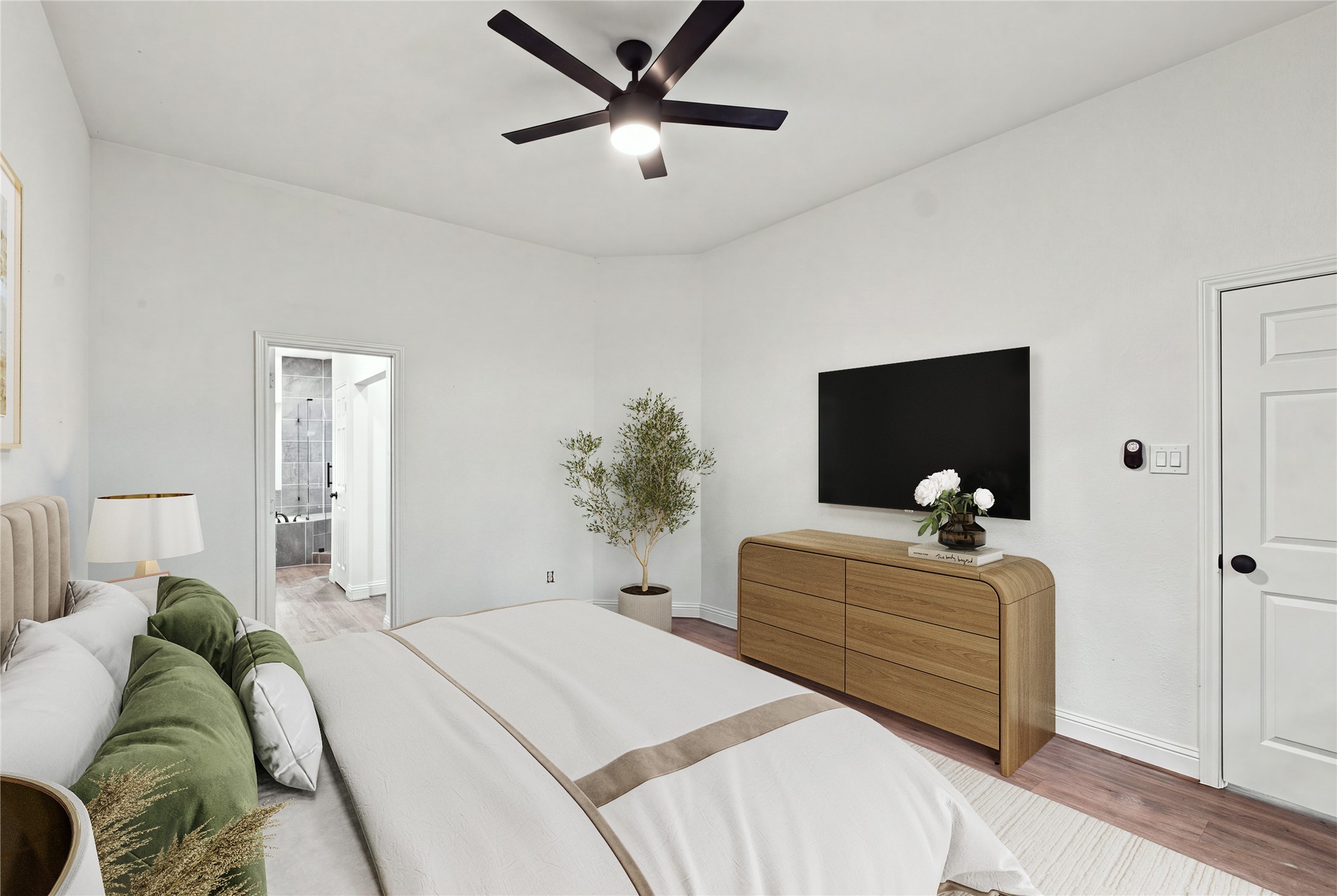 Spacious primary bedroom with direct access to the en-suite bath. Virtually staged for layout purposes.