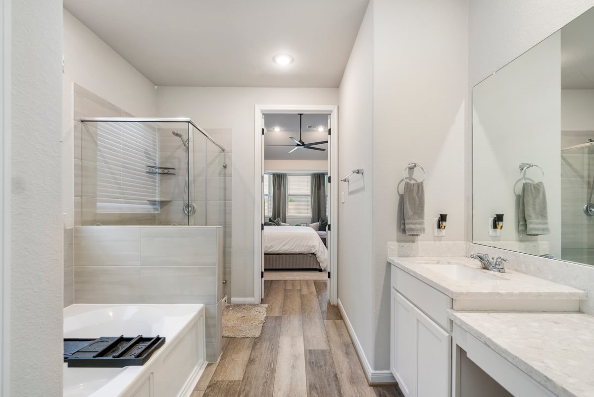 Why go to the spa when your primary bath looks like this?! Bright neutral paint compliments the modern tile and counter design!