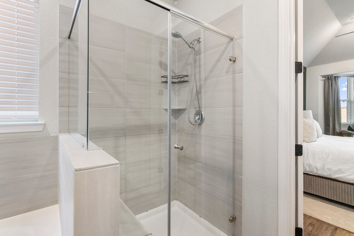 The glass enclosure highlights the stunning tiled shower!