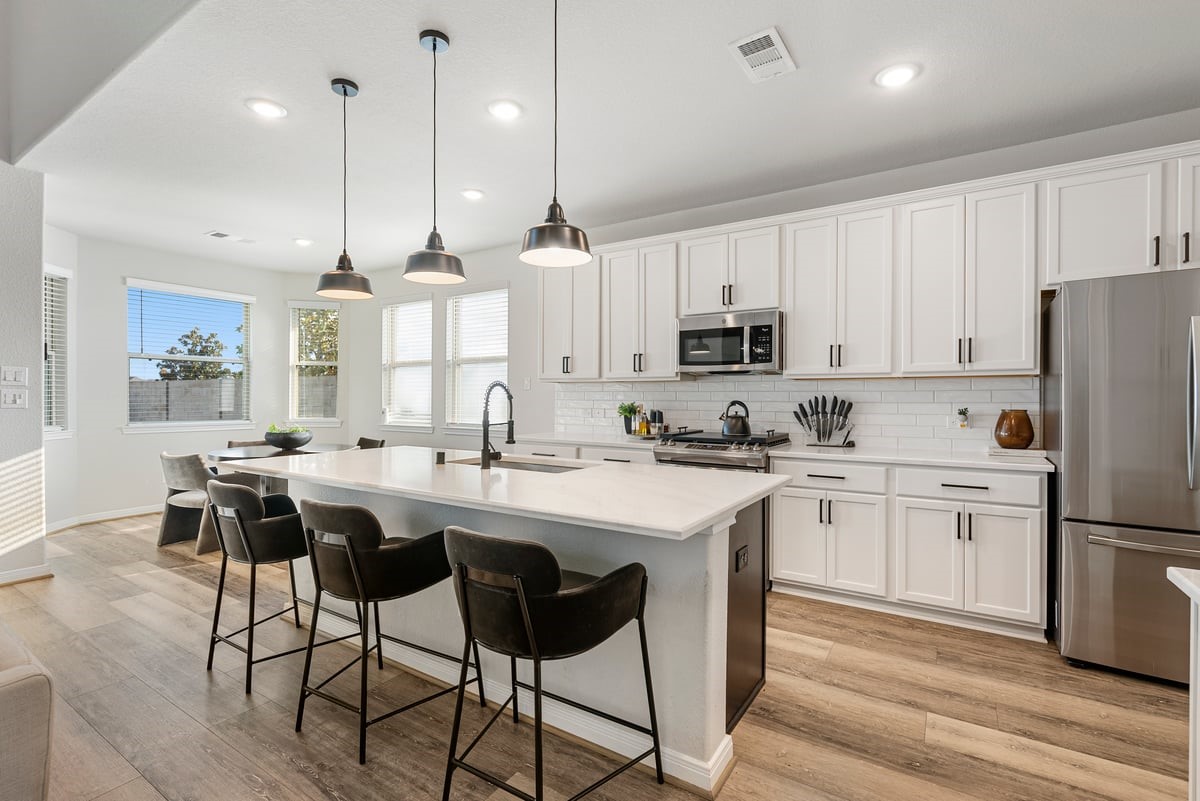 Never miss a minute of the action with this open concept living room and kitchen design! The upgrades continue with elegant pendant lighting and quartz counters!