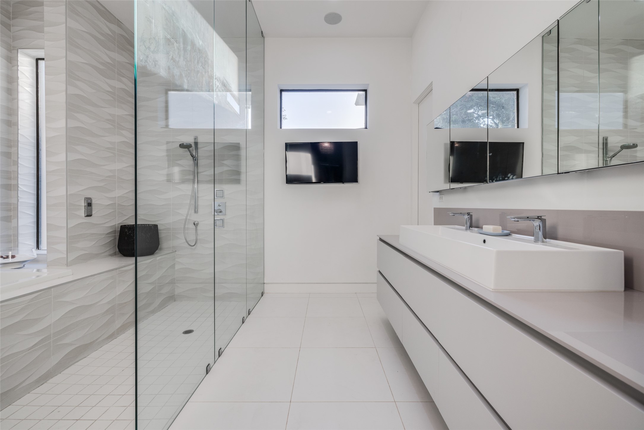 The gorgeous walk-in shower features designer stone tile, body sprayers, rainfall shower head, shower & soaking tub, lots of natural light, large sink with lots of drawer storage, heated floor, recently upgraded with Pedini cabinets