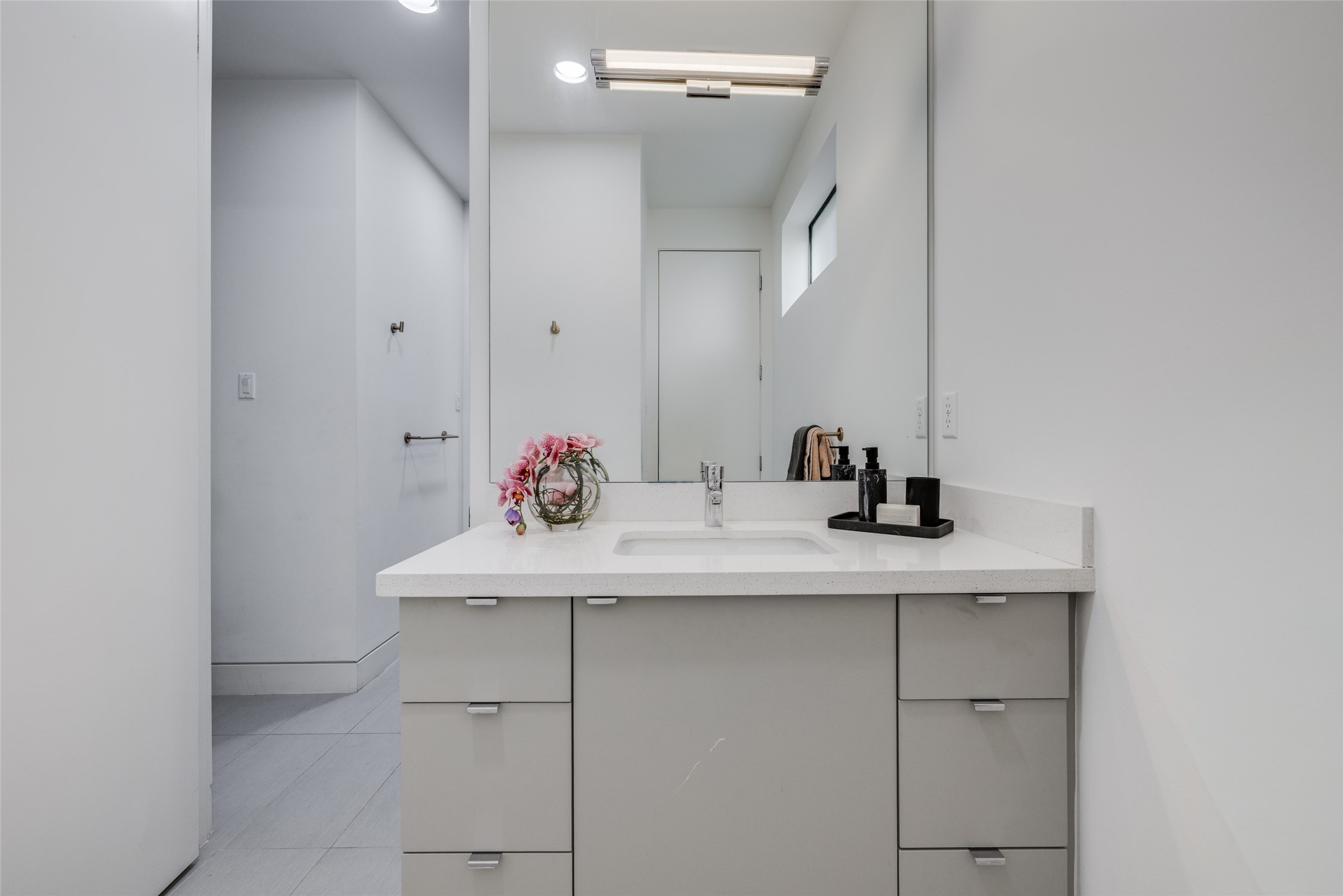 Jack & Jill Bathroom, private vanity areas, chrome Hansgrohe faucets, custom designer mirrors, pro flo commode, open shelving, neutral designer paint throughout