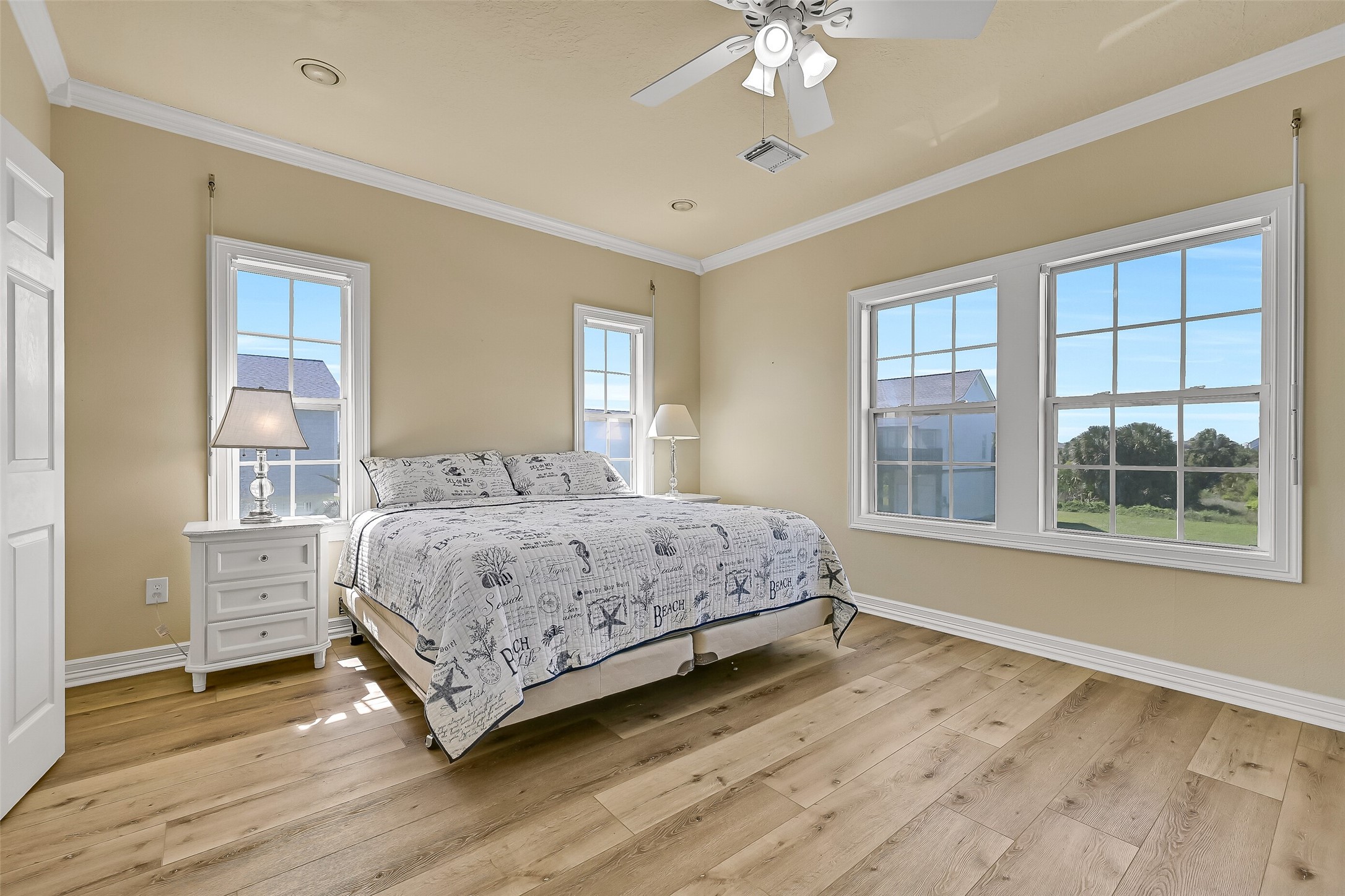 The last bedroom you will come across is the spacious primary suite with en-suite bathroom. This room features high ceilings, walls of windows, and can easily accommodate different furniture layouts.
