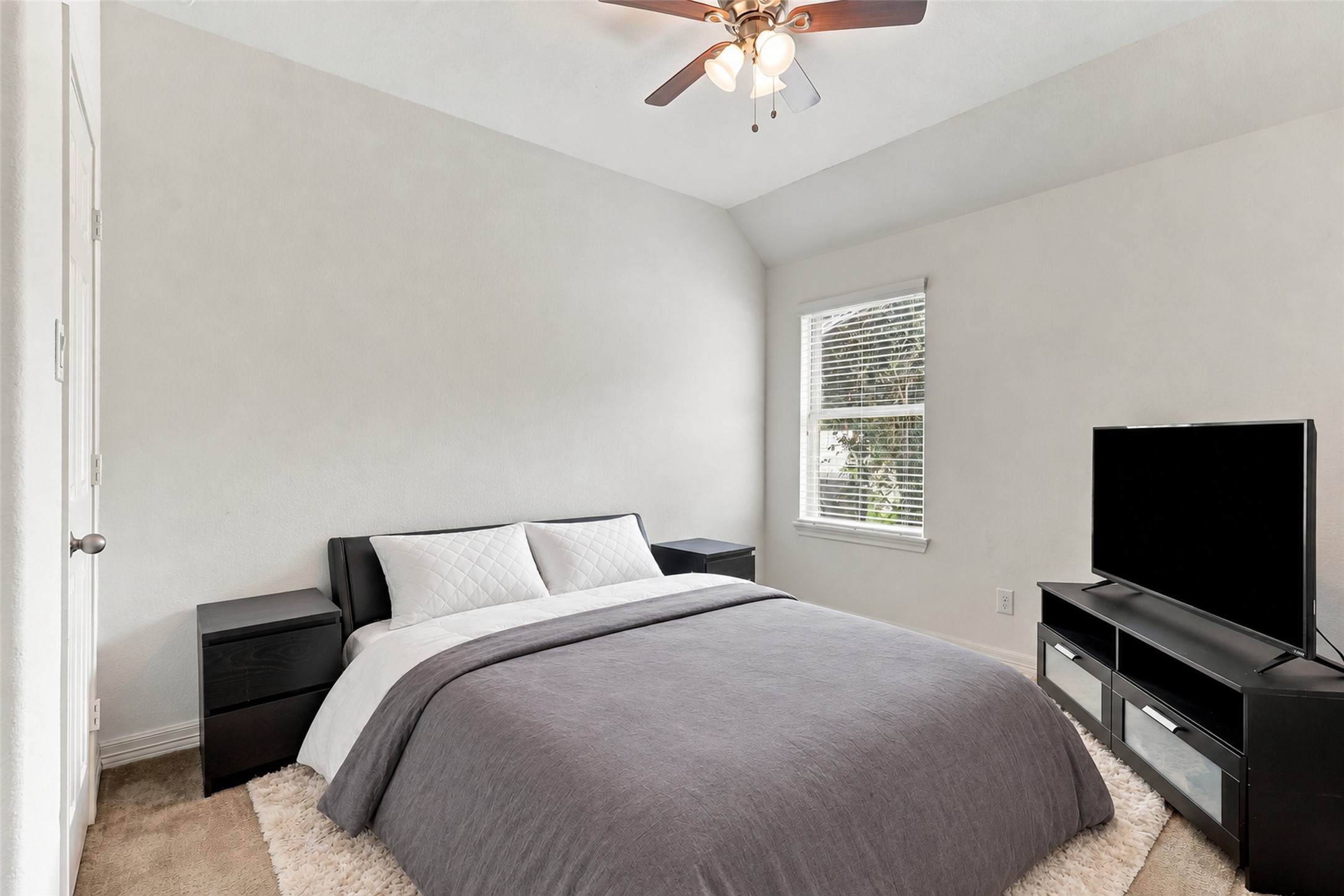 Secondary bedroom with a ceiling fan and natural light.