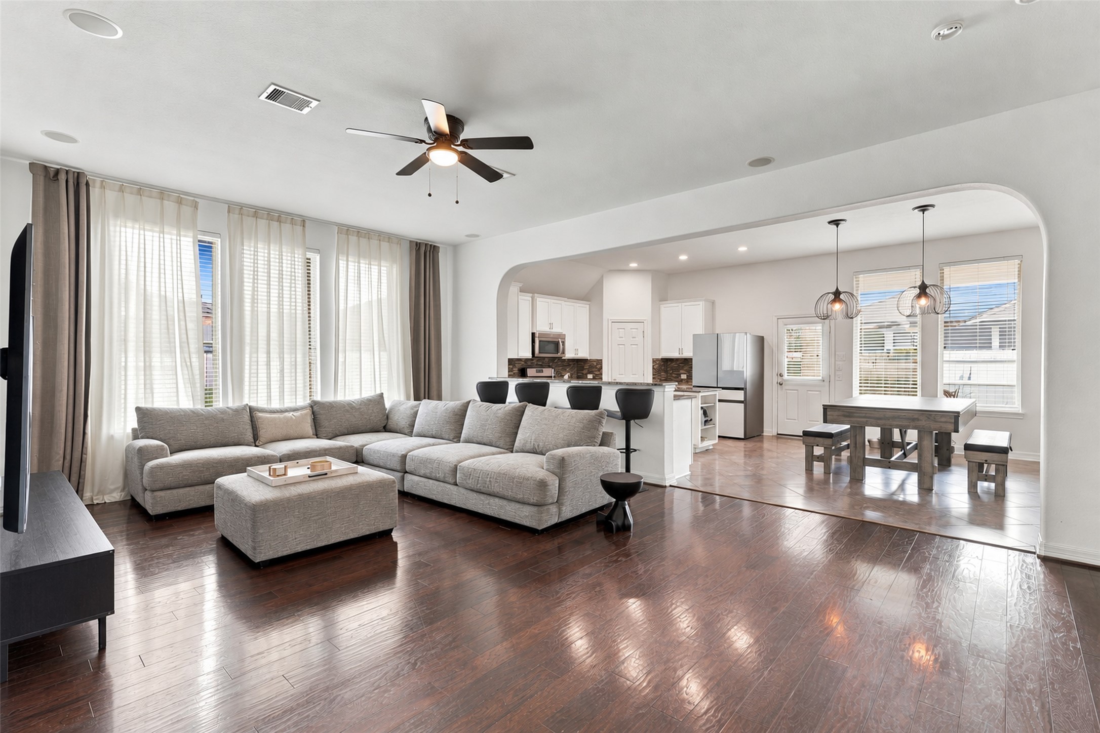 Alternate living room view showcasing breakfast bar seating and French doors to the office.