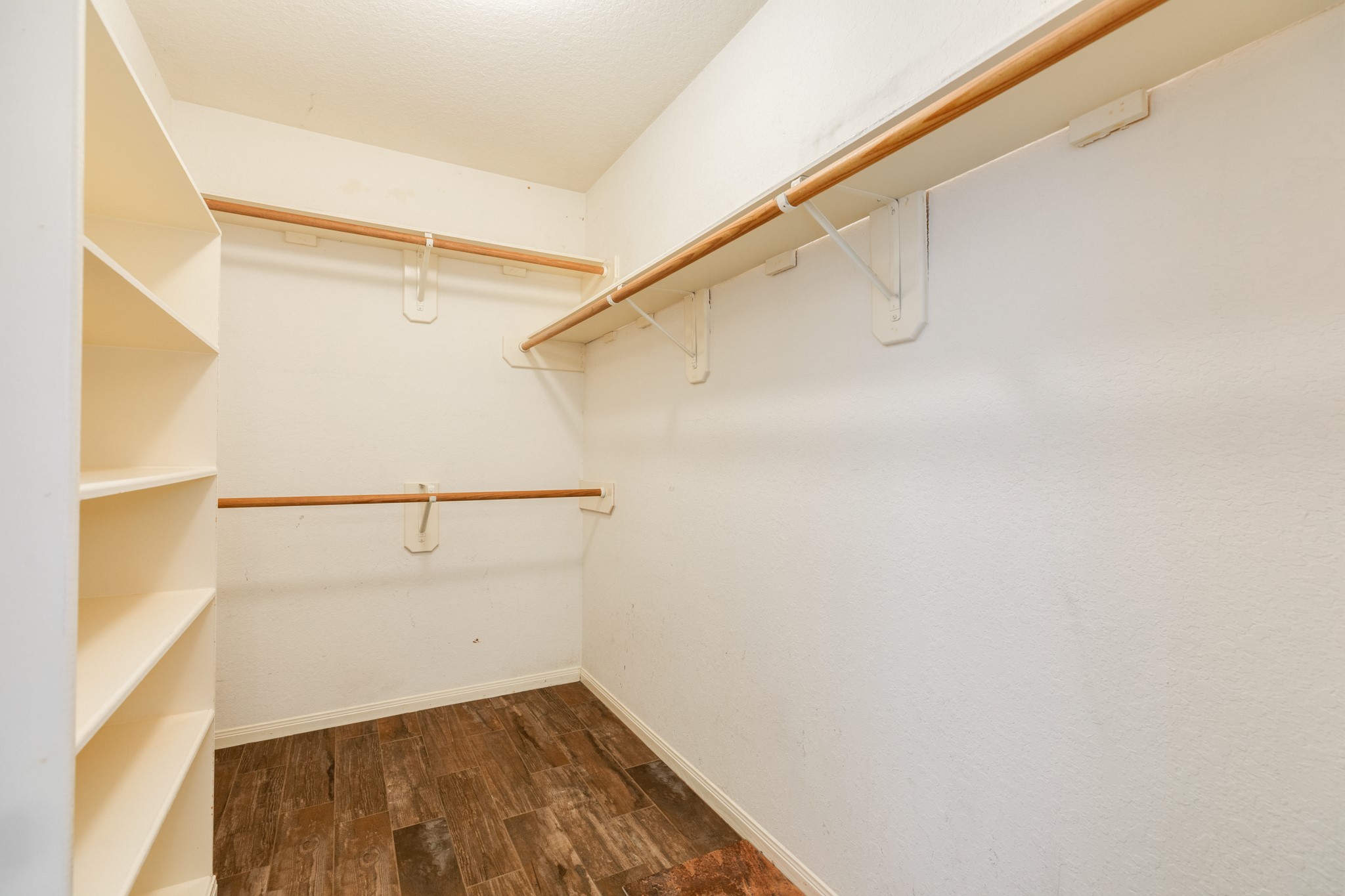 Spacious walk-in closet featuring ample shelving and hanging space.