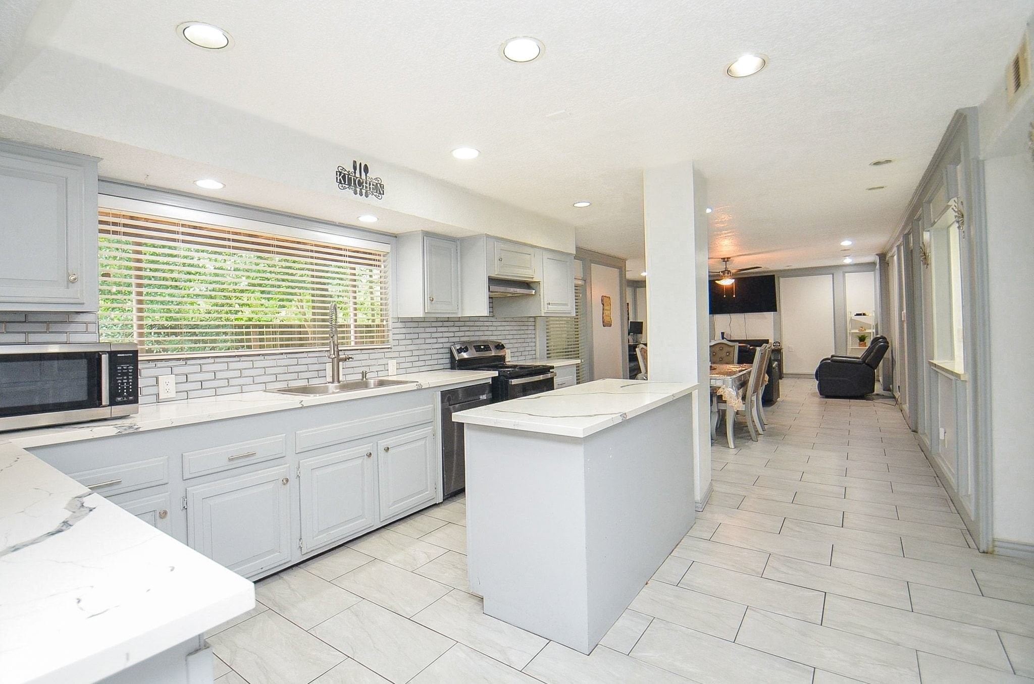 Chef-inspired kitchen designed for style and functionality! Notice the crisp white/gray cabinetry, elegant countertops, classic backsplash and stainless steel appliances.