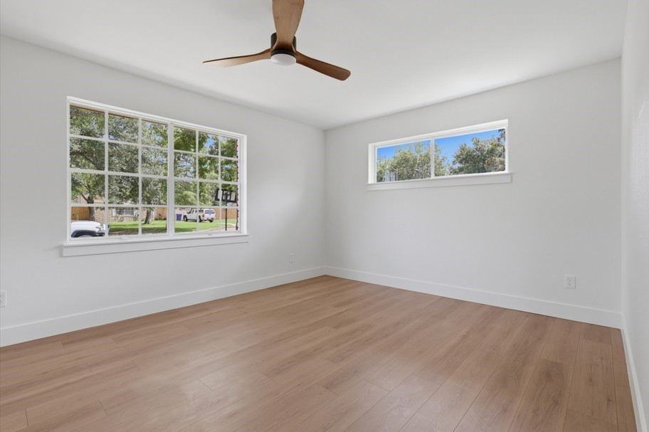 The spacious bedrooms are complemented by abundant natural light, beautiful wood floors, and new ceiling fans, creating a comfortable and inviting retreat.