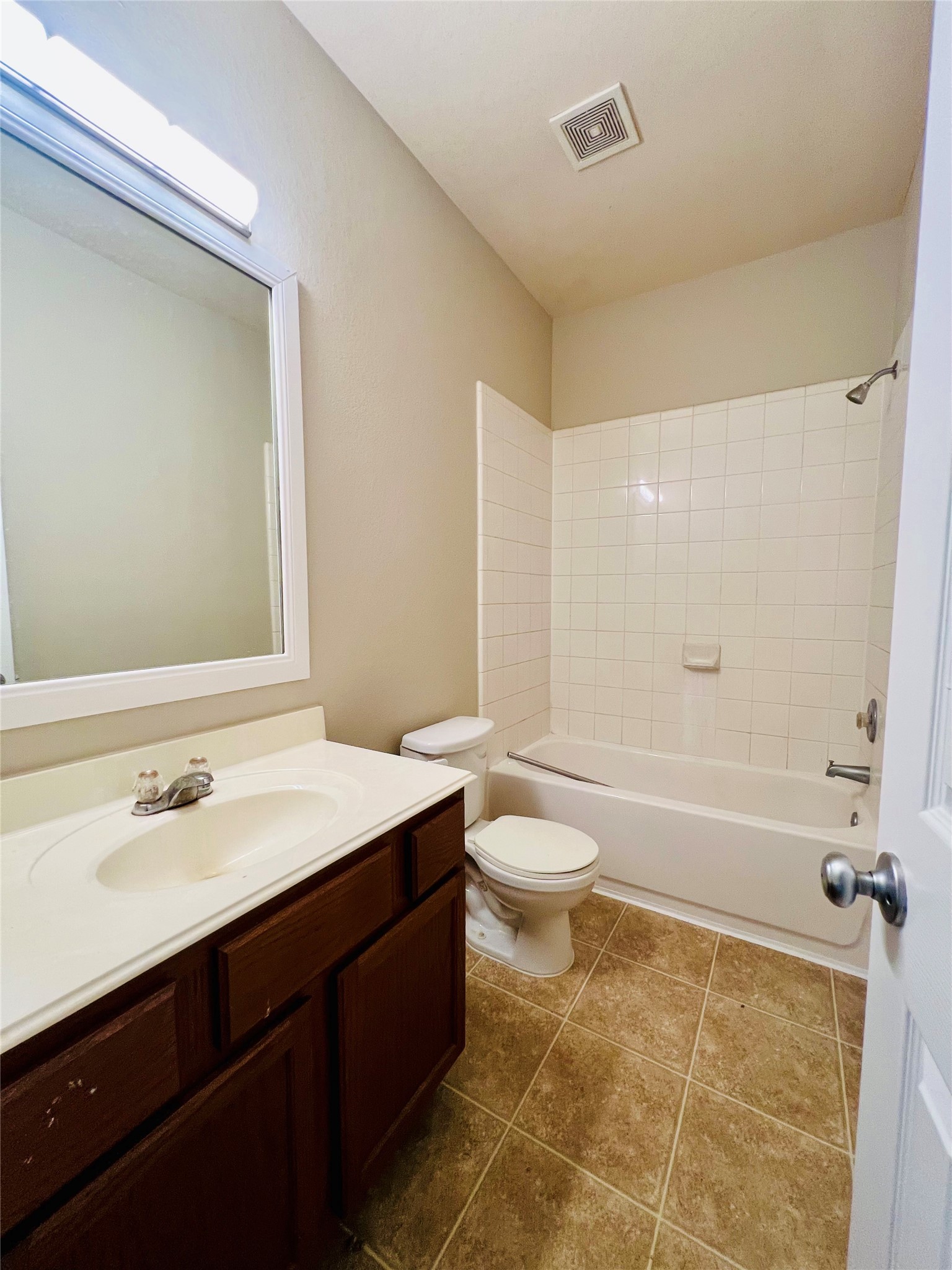 Bright and inviting bathroom featuring a classic white tile bathtub, elegant vanity, and neutral tones for a calming ambiance.