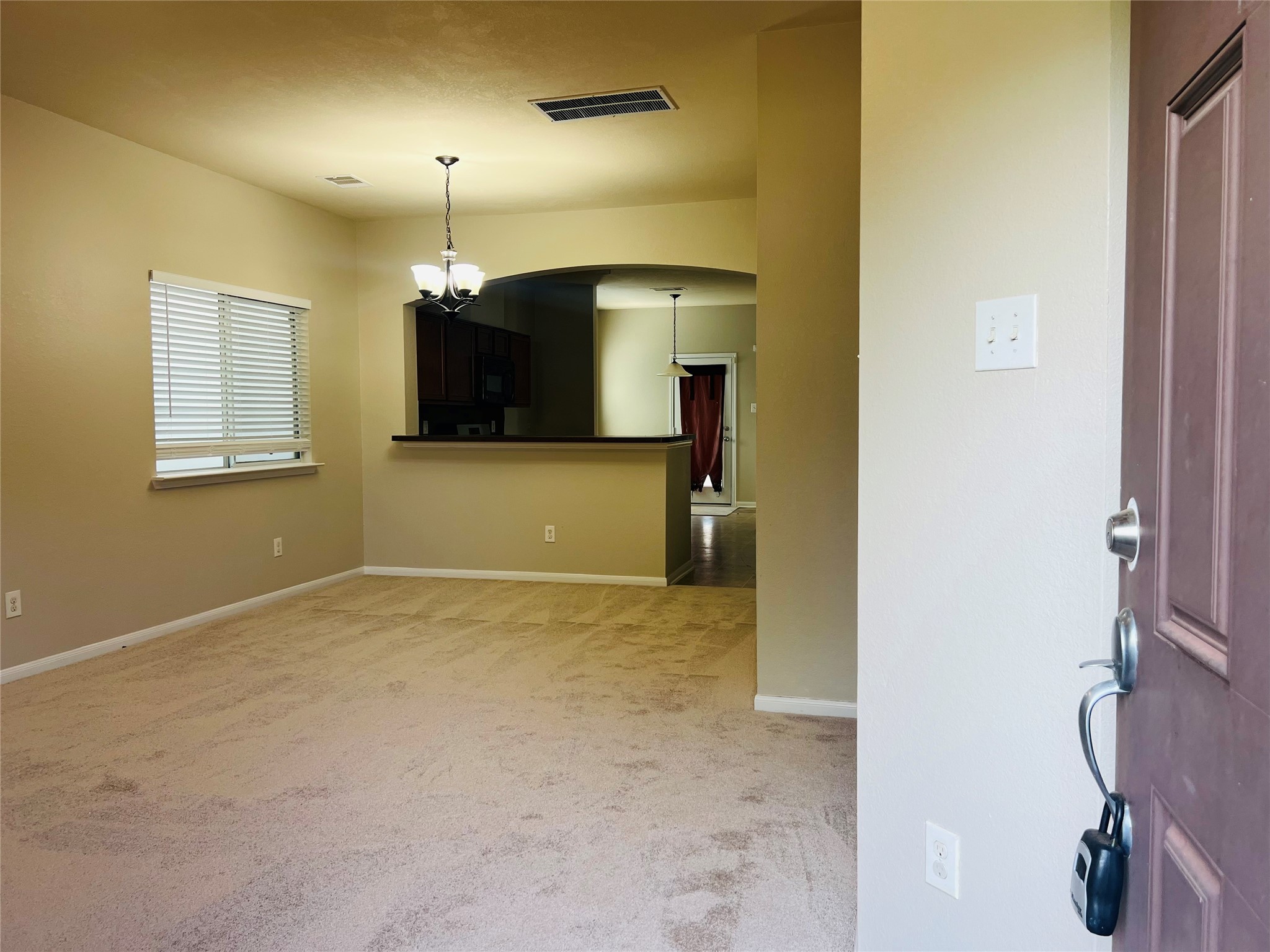 Inviting entryway leading into a spacious open-concept living area with soft carpeting, neutral tones, and abundant natural light. Inviting entryway leading into a spacious open-concept living area with soft carpeting, neutral tones, and abundant natural light.